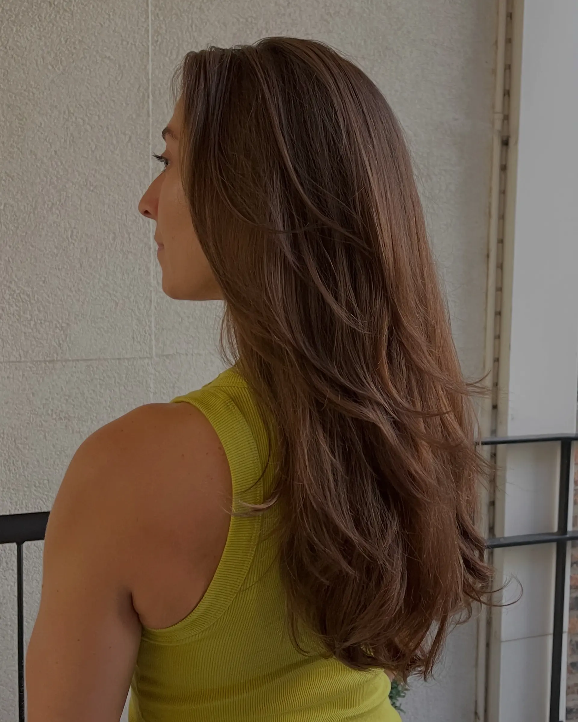 Long espresso brunette hair styled with soft, cascading layers and rounded ends for effortless volume and texture. 1