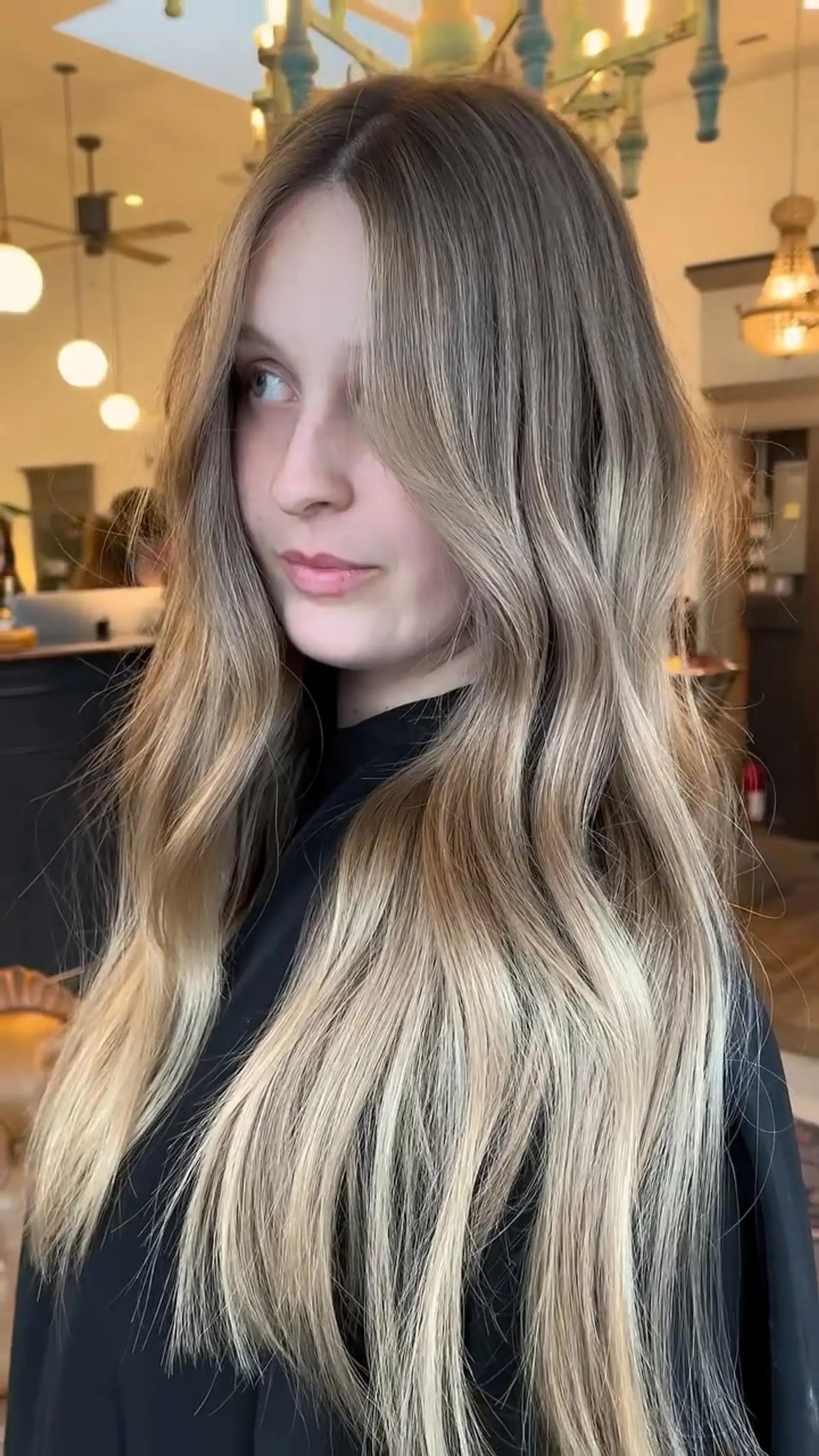 Long honey blonde balayage styled with soft, loose waves and face-framing layers. 1