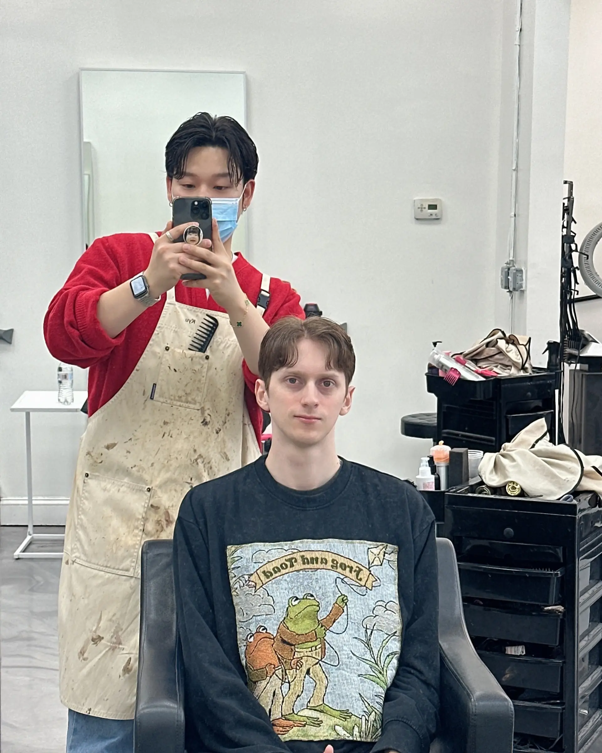 A men's short haircut styled into a soft center-parted curtain fringe with natural wave. 1
