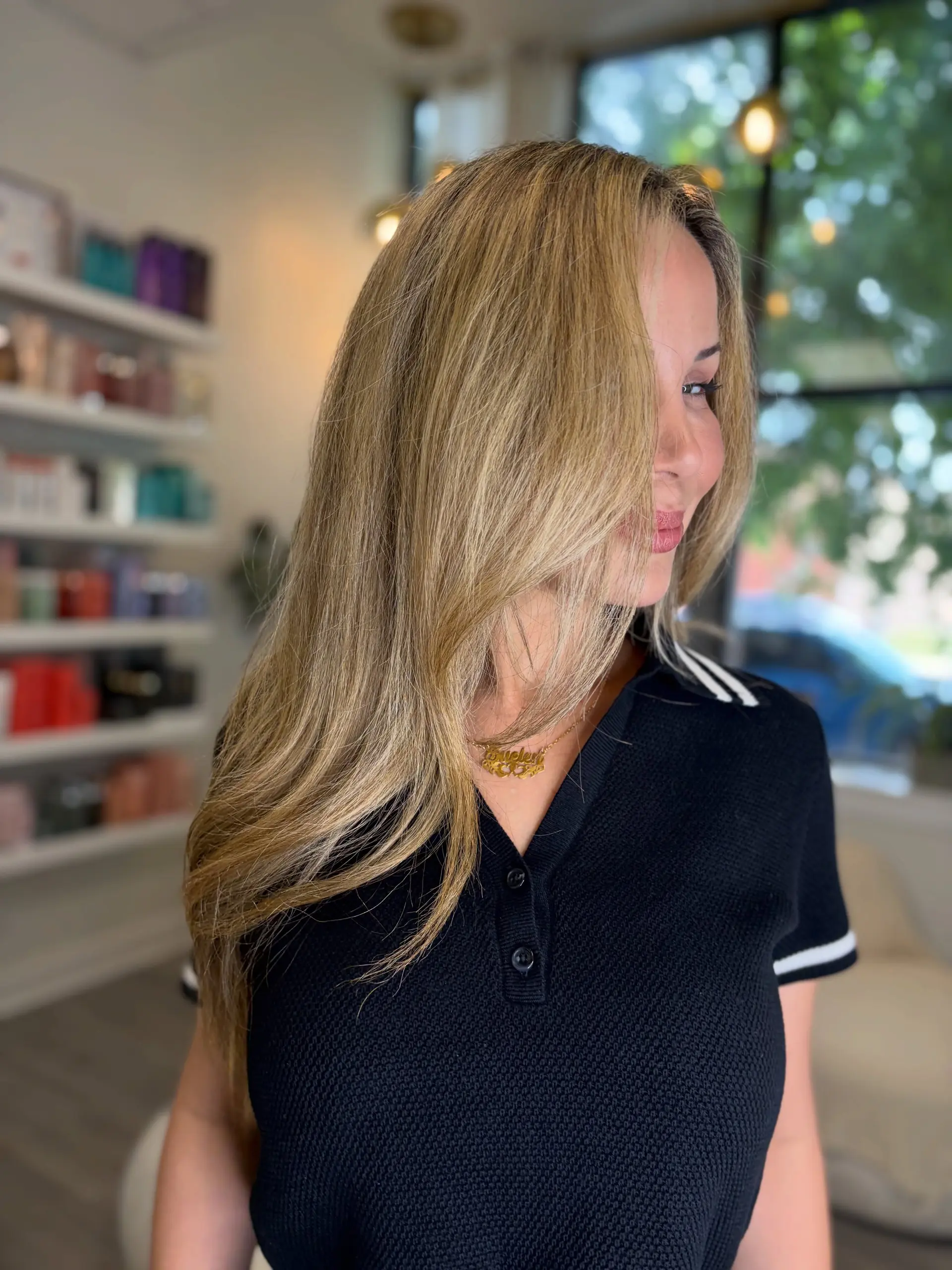 A voluminous golden blonde blowout featuring soft face-framing layers and smooth, healthy shine. 1