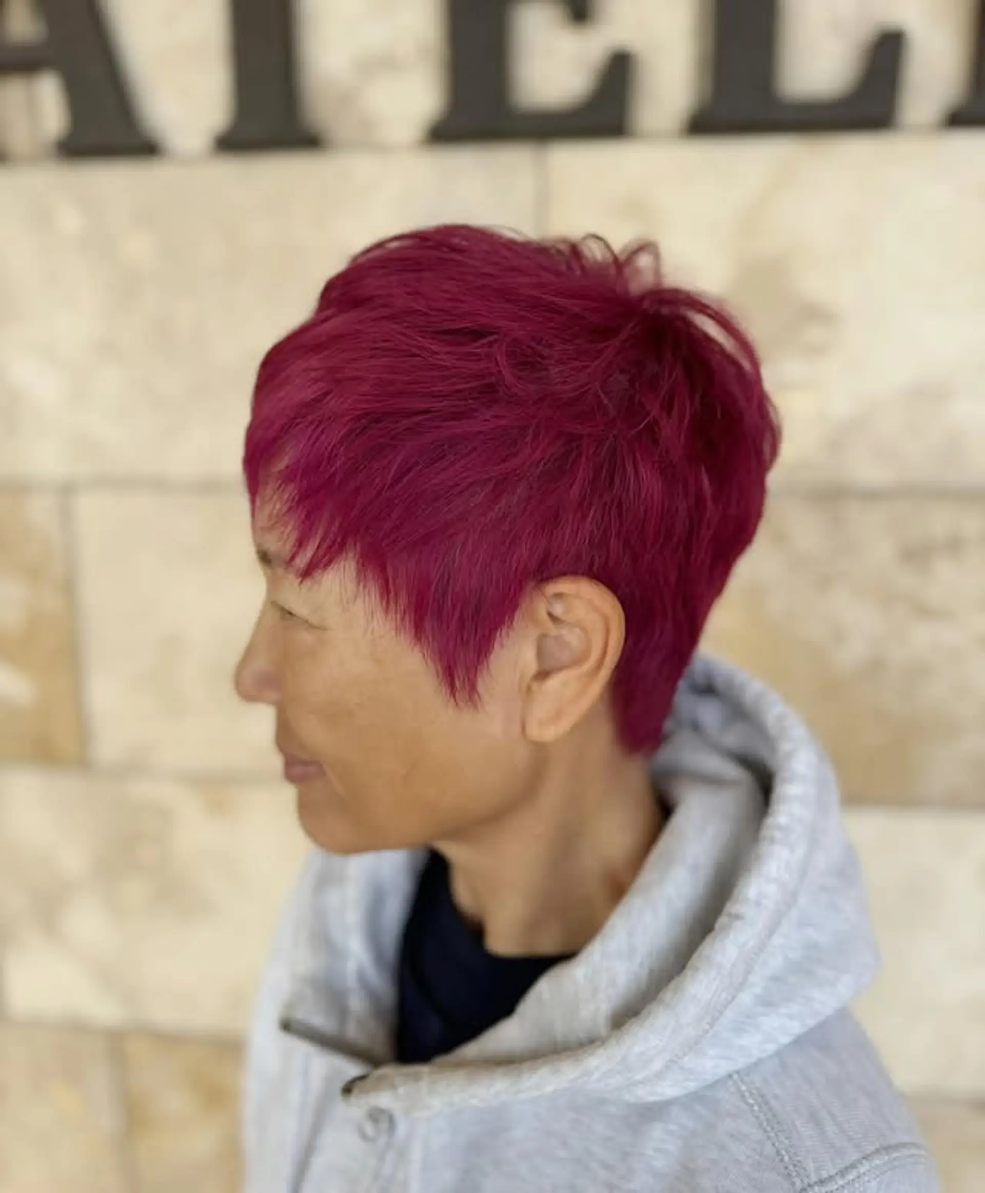 A short, textured pixie cut with a vibrant red color. 1