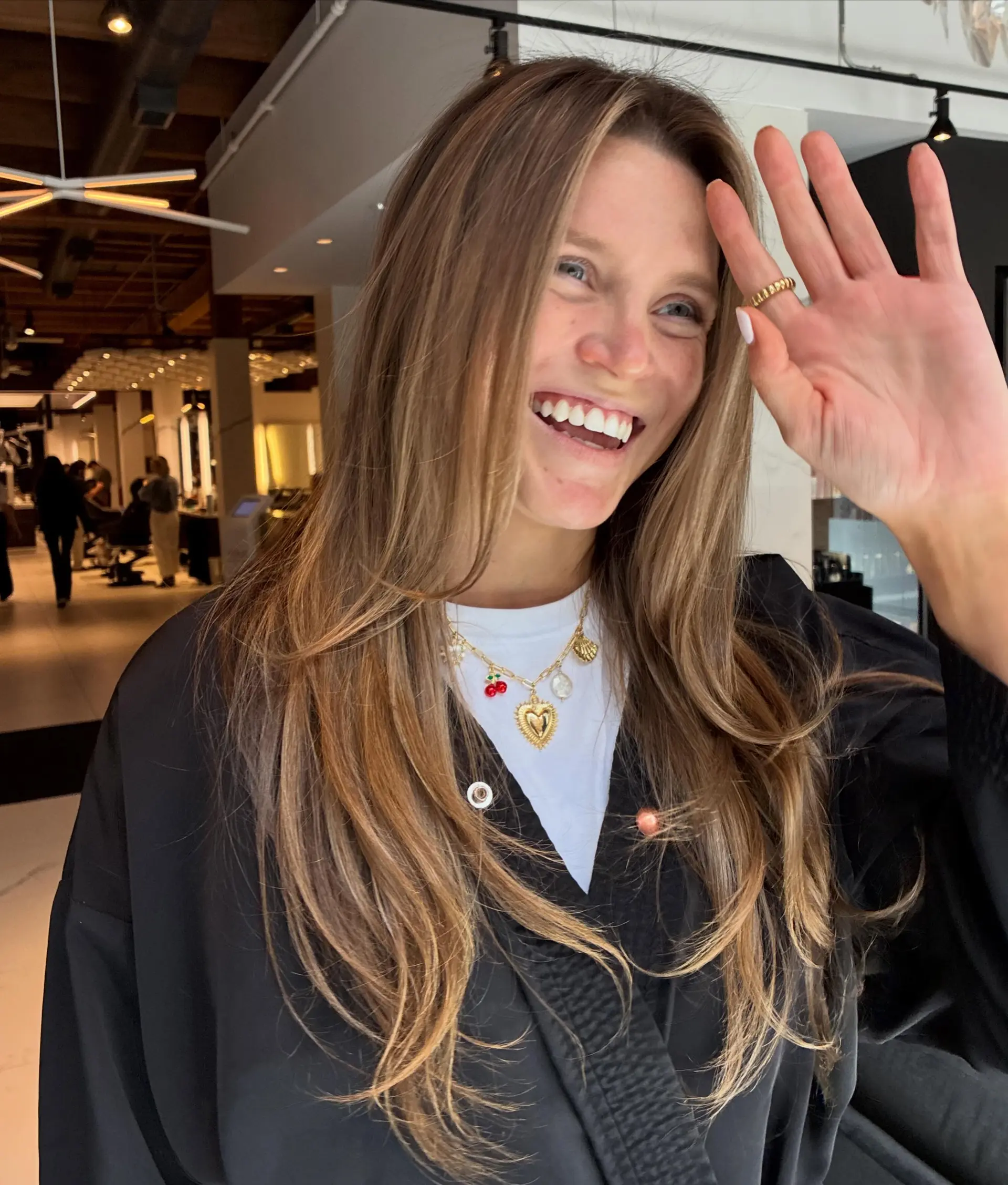Long brunette hair featuring subtle honey balayage highlights with face-framing layers and soft blowout texture. 1