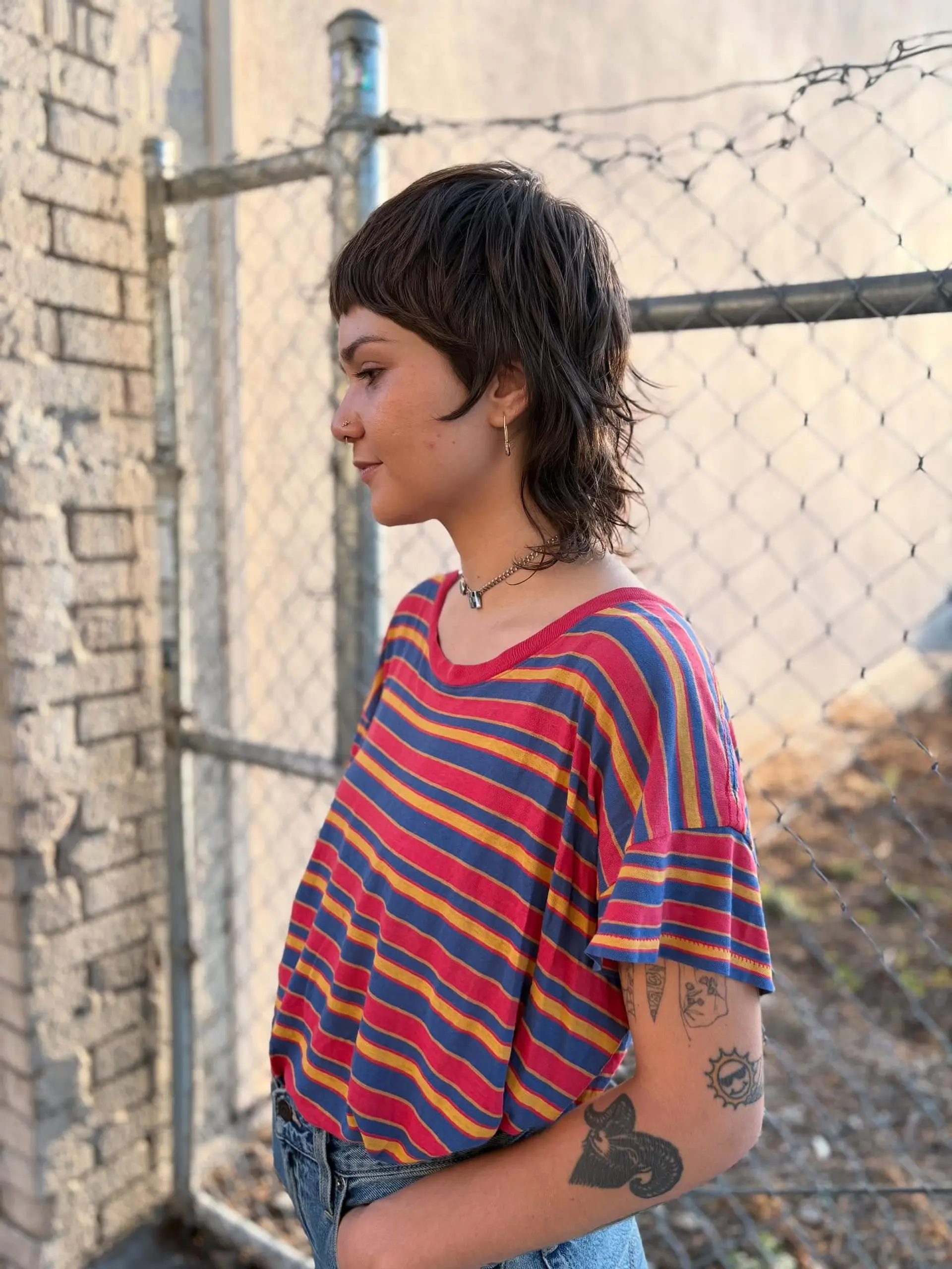 A razor-cut shaggy mullet featuring micro fringe, textured ear-framing layers, and wispy length through the nape. 1