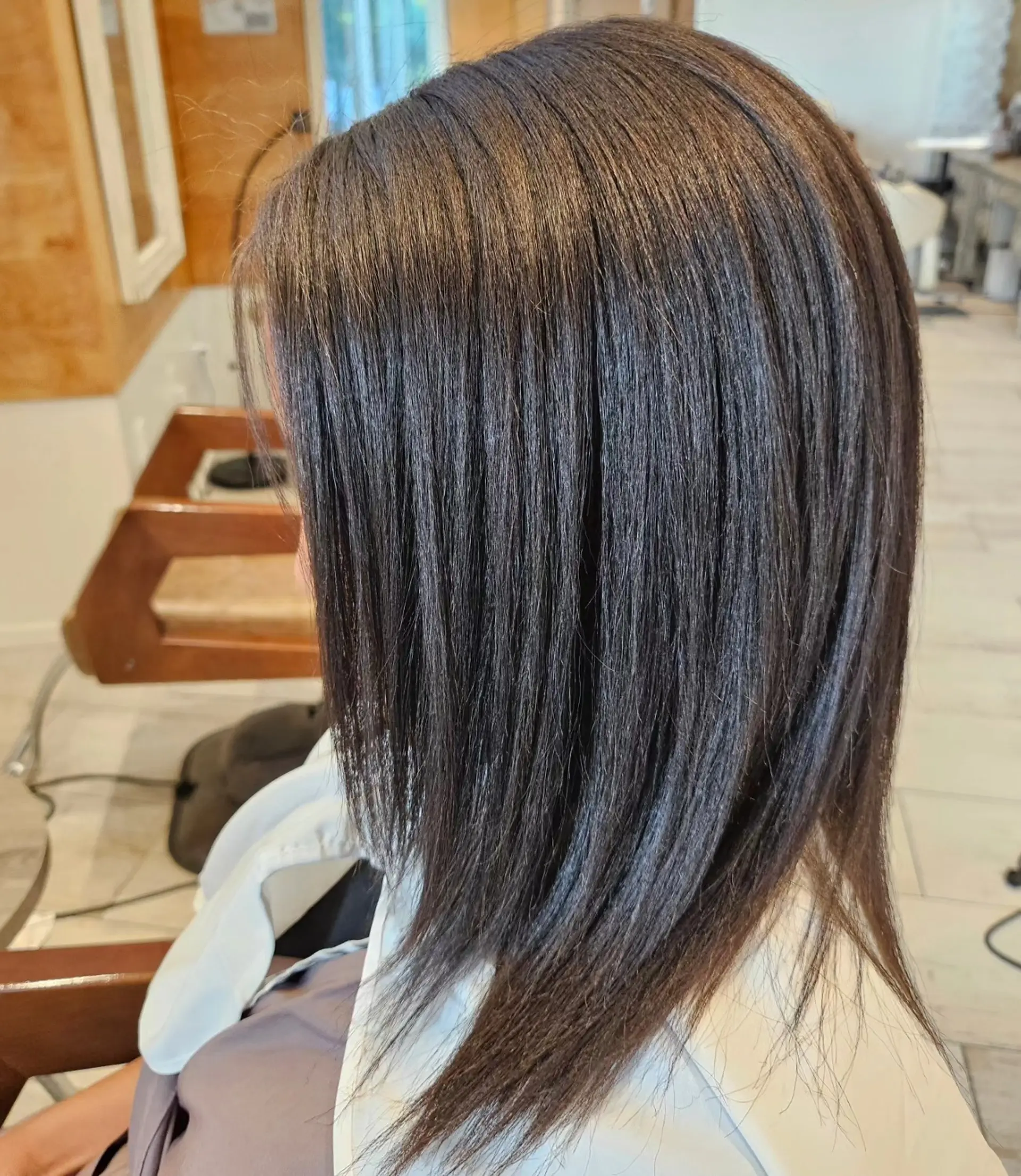 Smooth and glossy straight hair falling evenly past the shoulders. 1