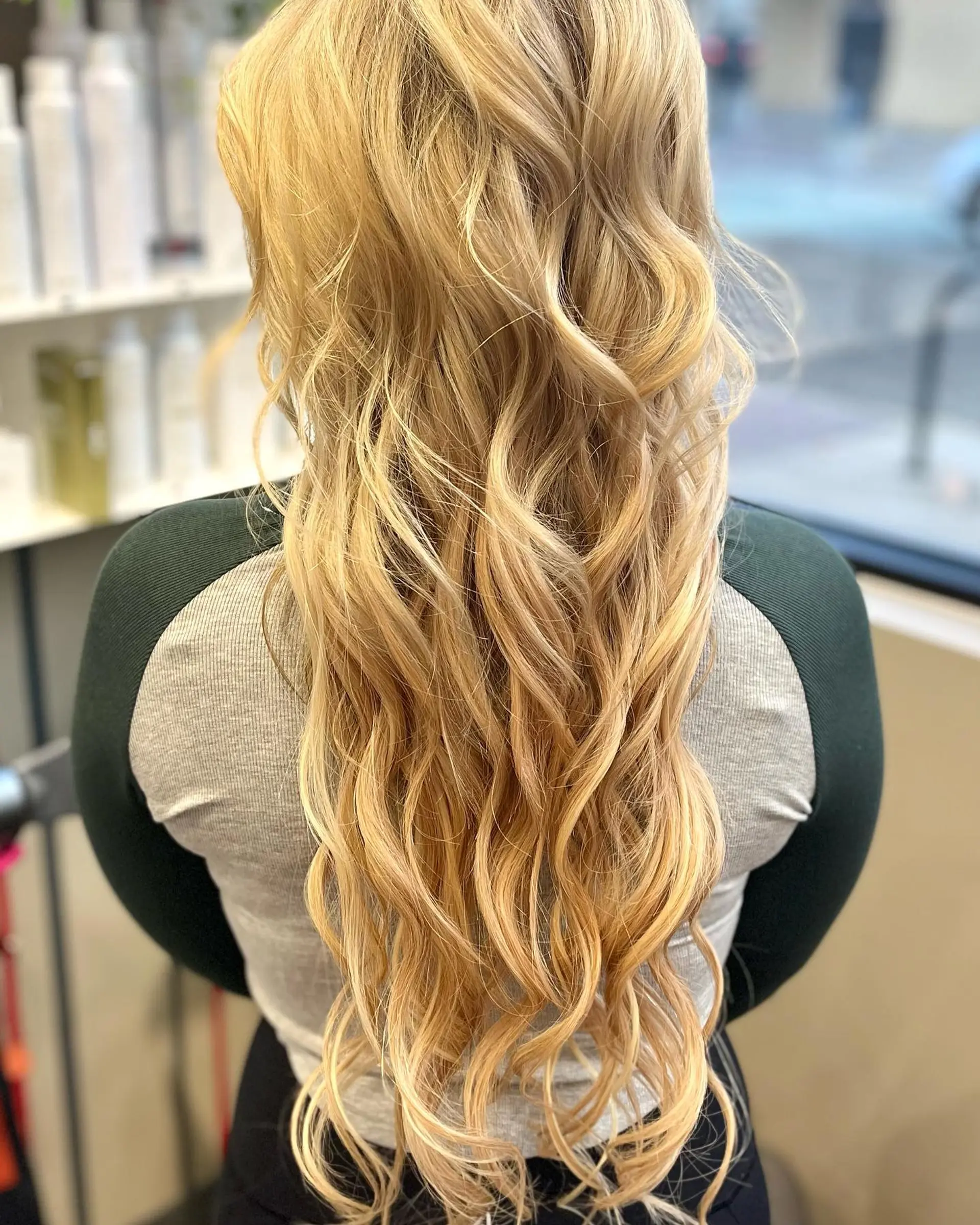 Long blonde hair styled into soft, beachy waves. 1