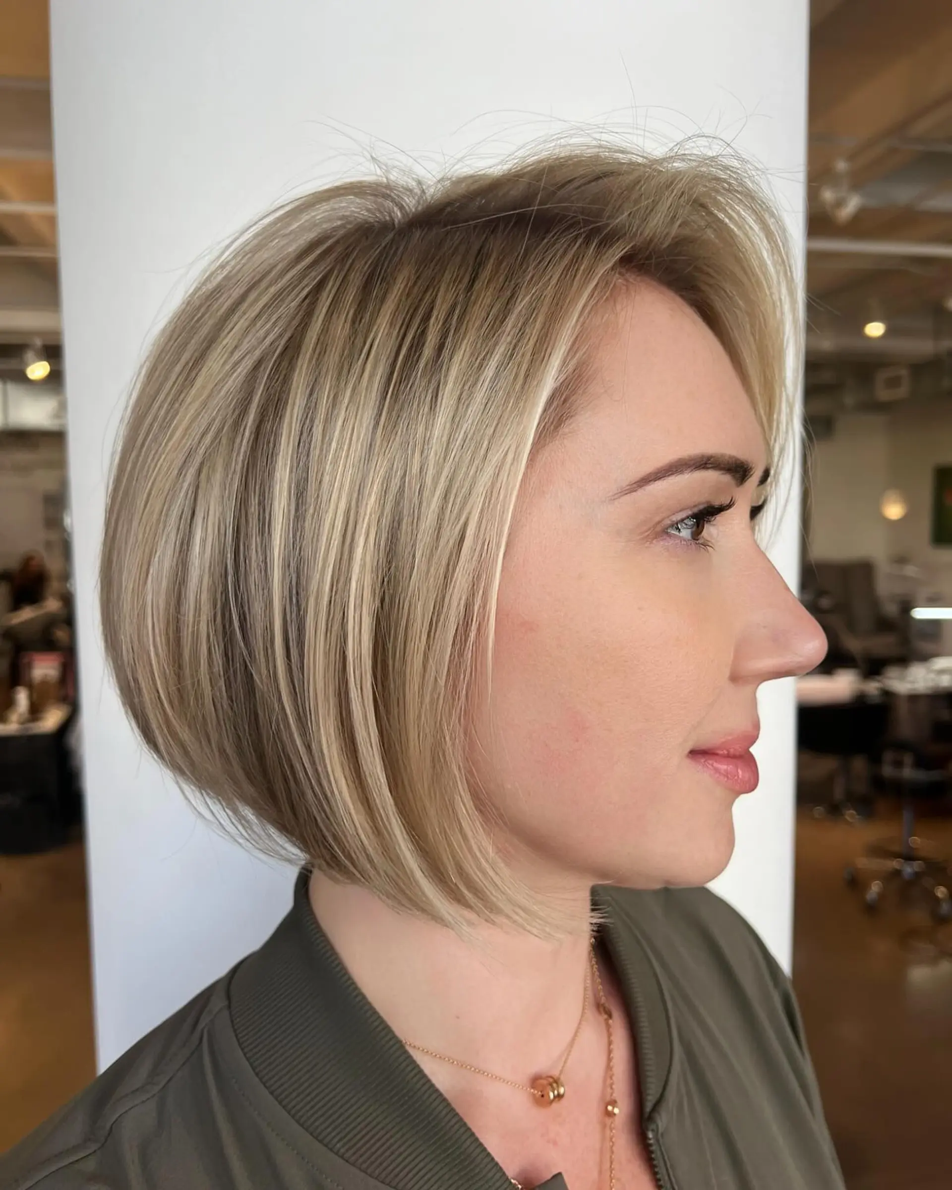 A sleek, angled chin-length bob with blended dimensional blonde highlights. 1
