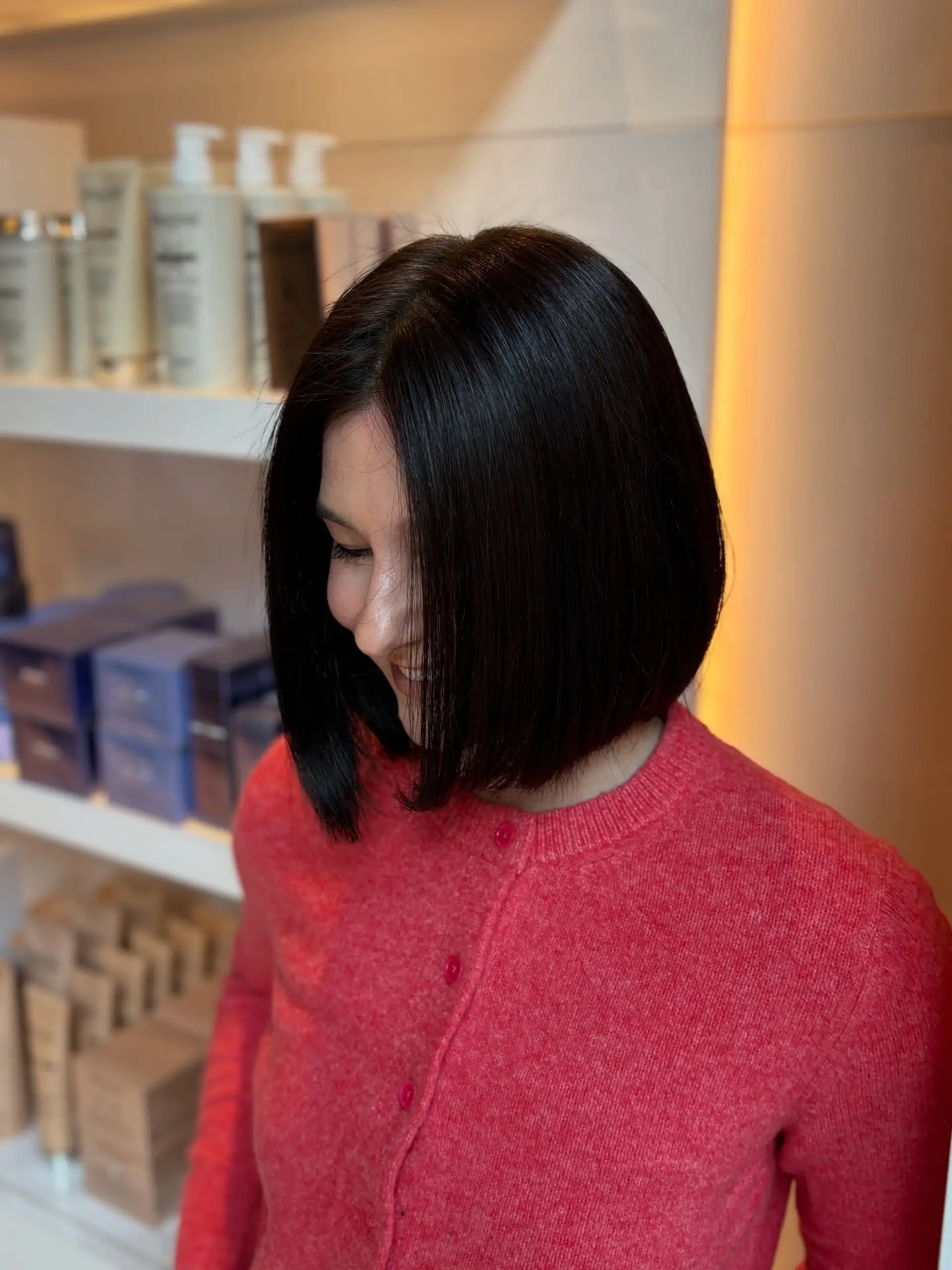 A sleek and glossy dark blunt bob cut to the chin with a clean finish. 1