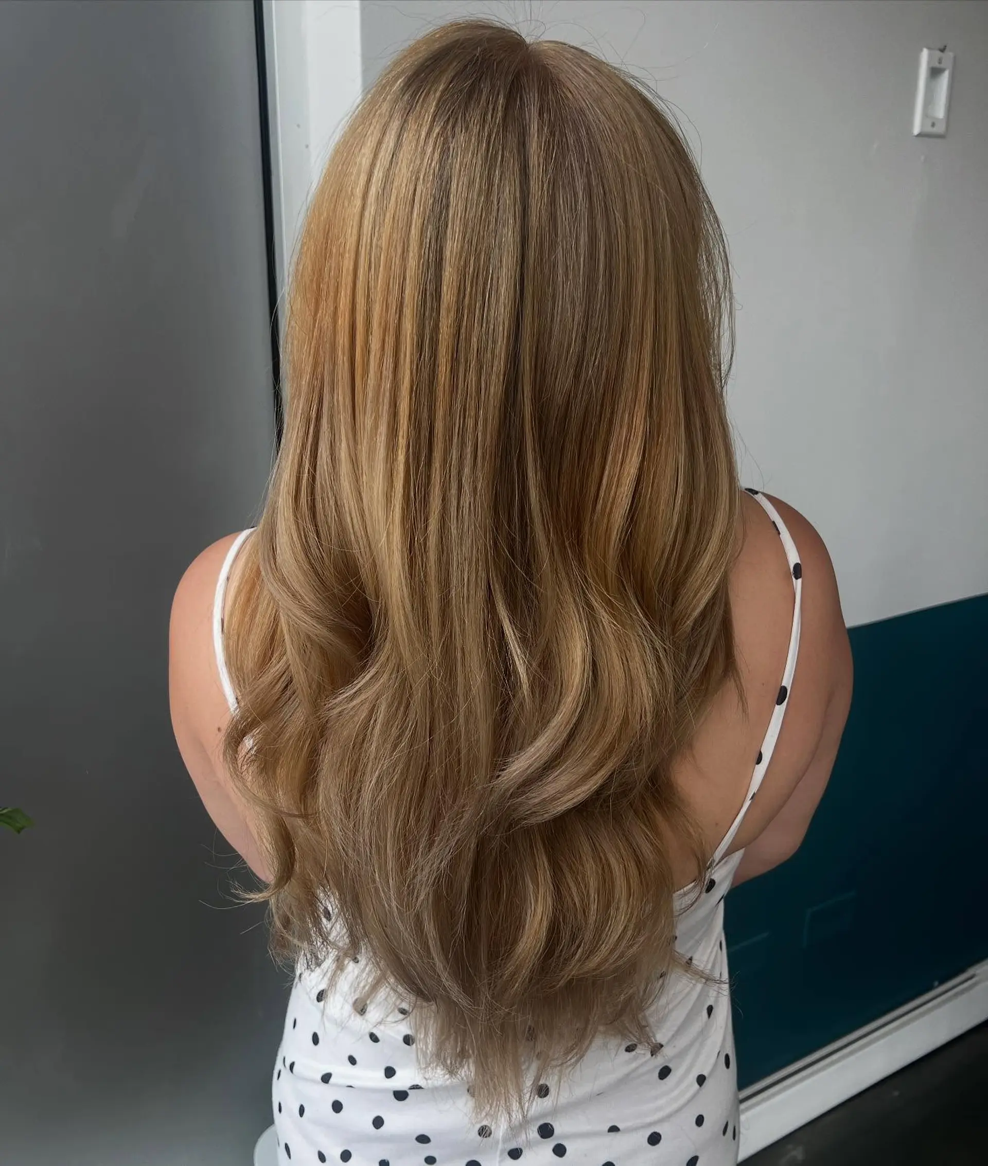 A very long, straight, layered hairstyle with golden blonde waves. 1