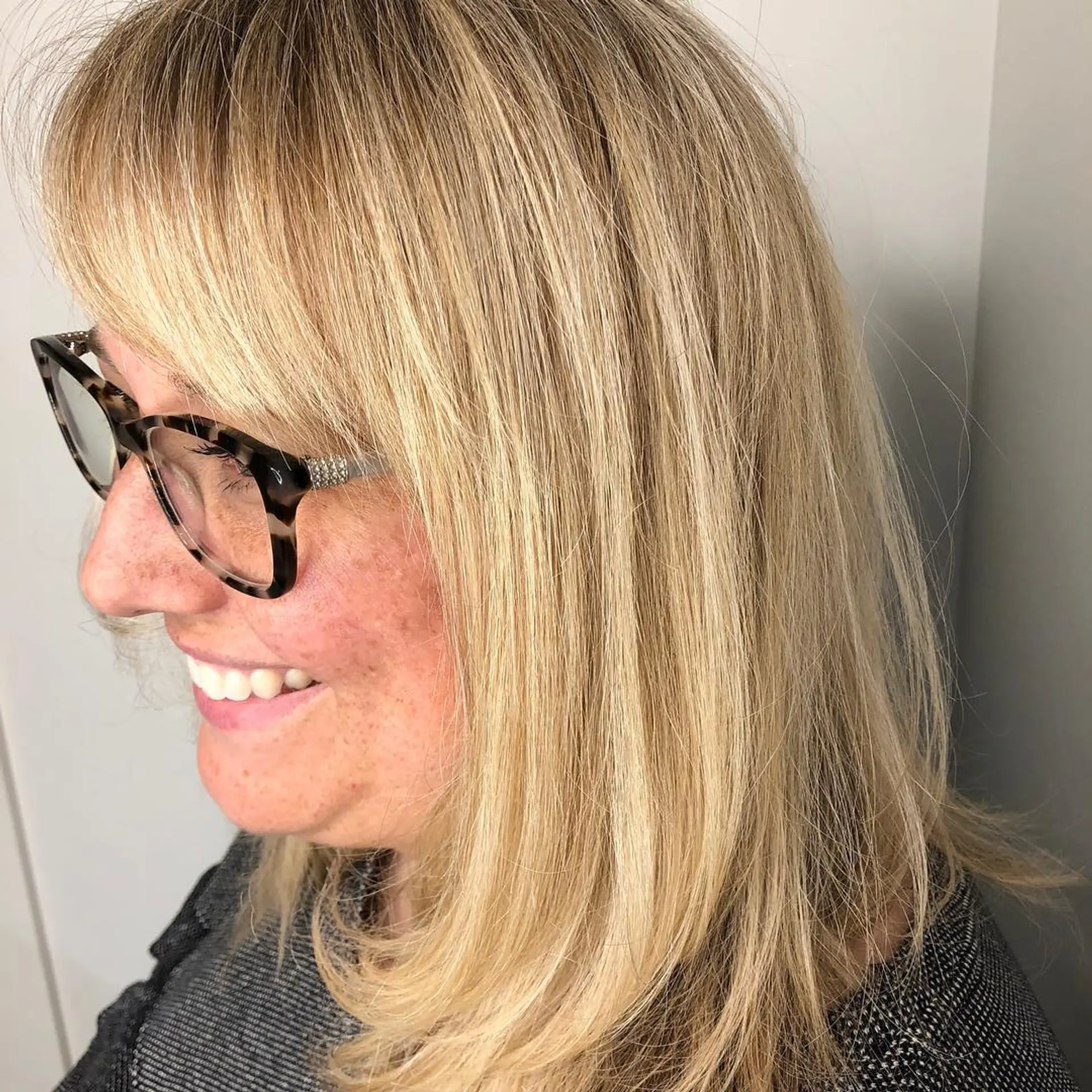 Shoulder-length blonde hair featuring dimensional foil highlights, soft inward curved ends, and side-swept fringe bangs. 1