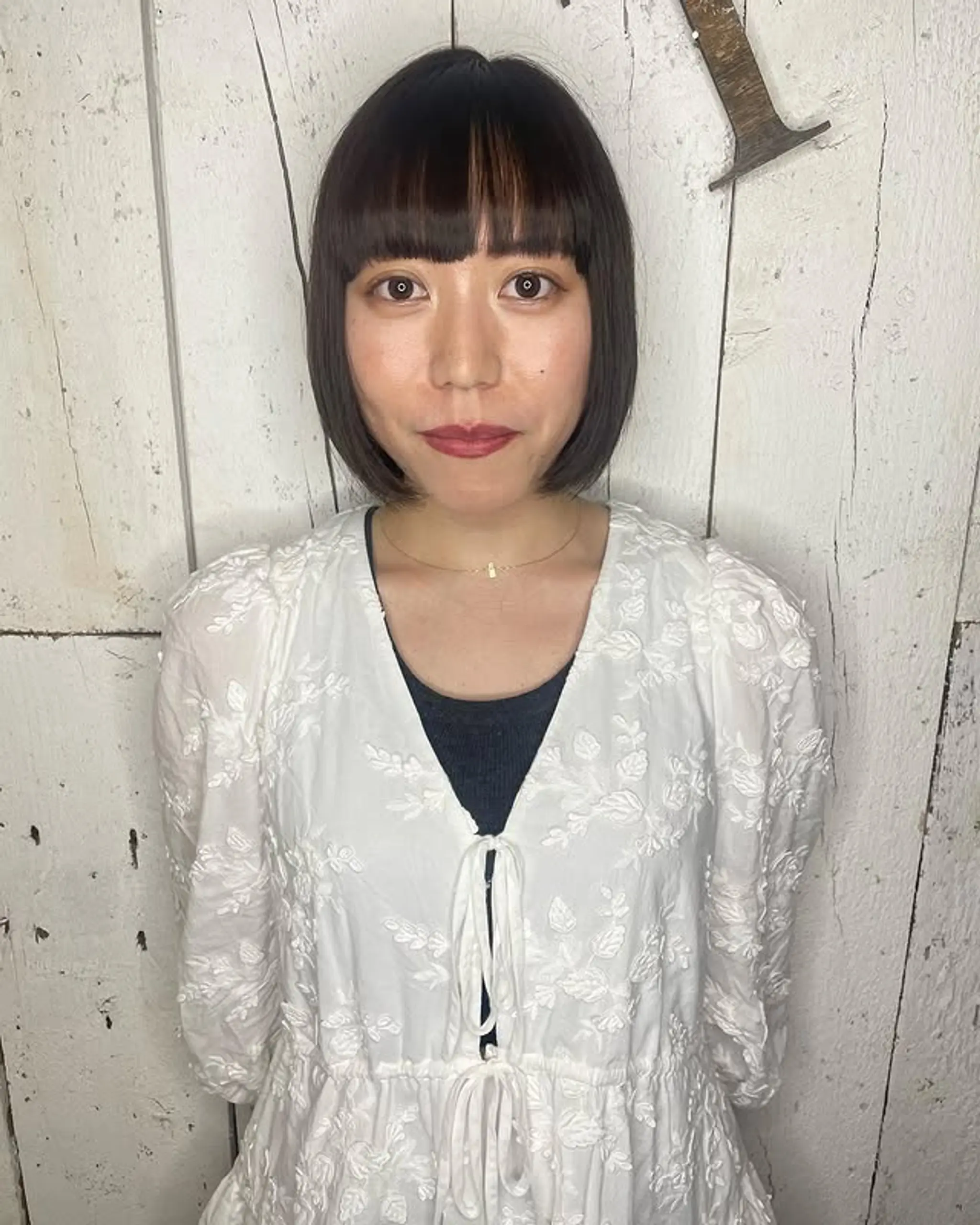 A sleek, chin-length bob with blunt, straight-across bangs.
