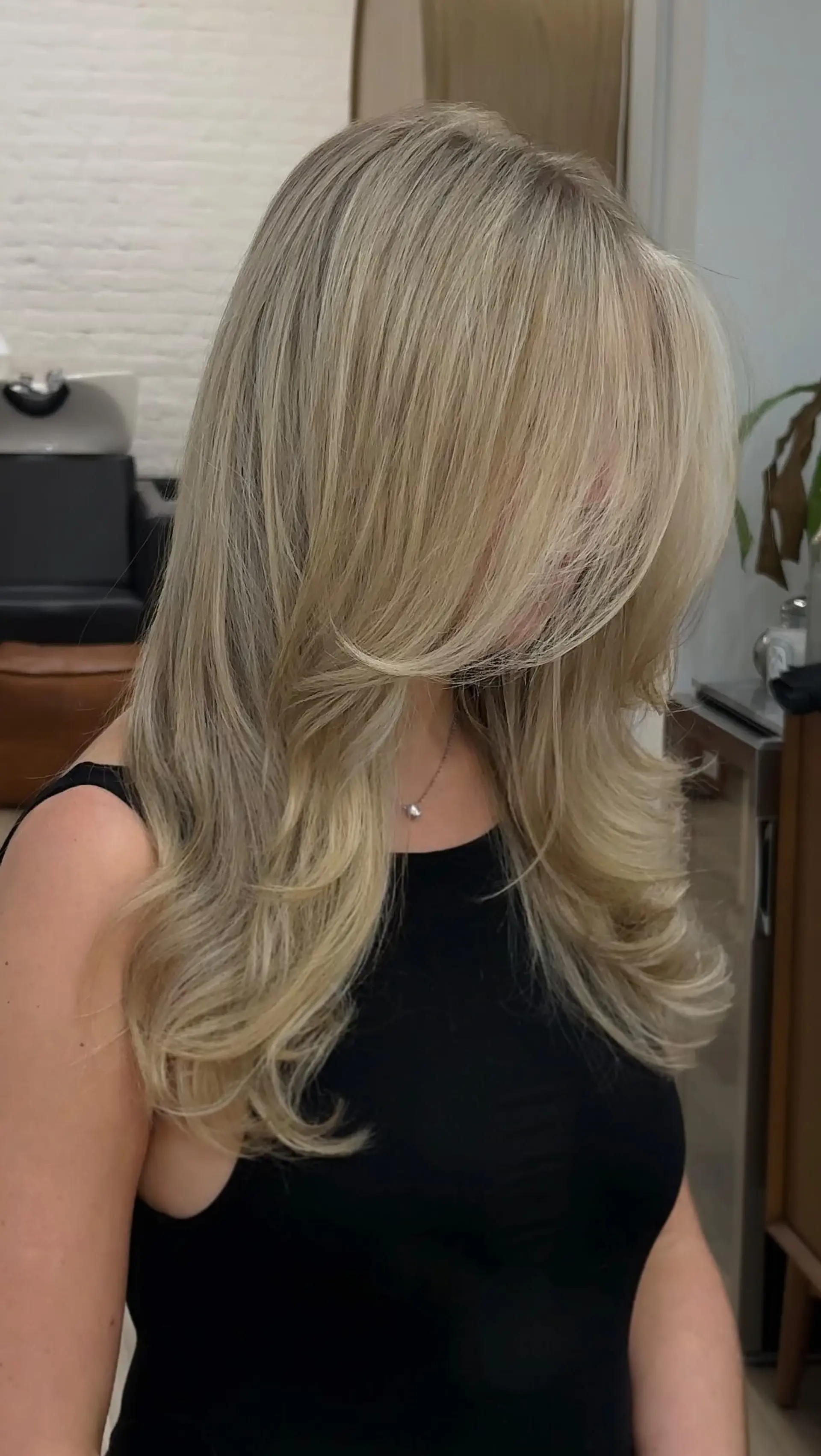 Long, multi-tonal bright blonde hair styled in a bouncy, voluminous blowout with rounded, flipped ends. 1