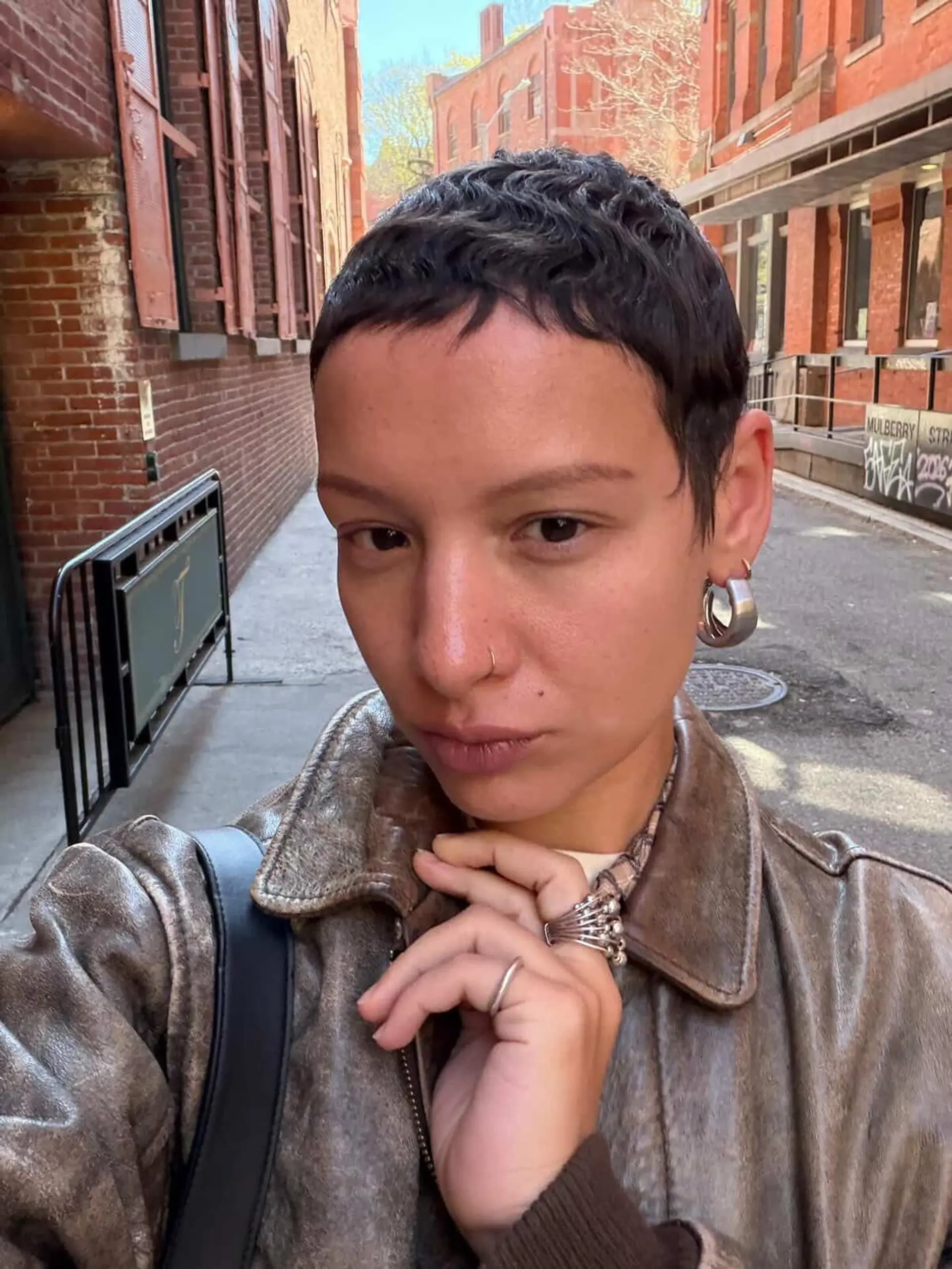 A textured short pixie cut with delicate micro bangs framing the forehead. 1