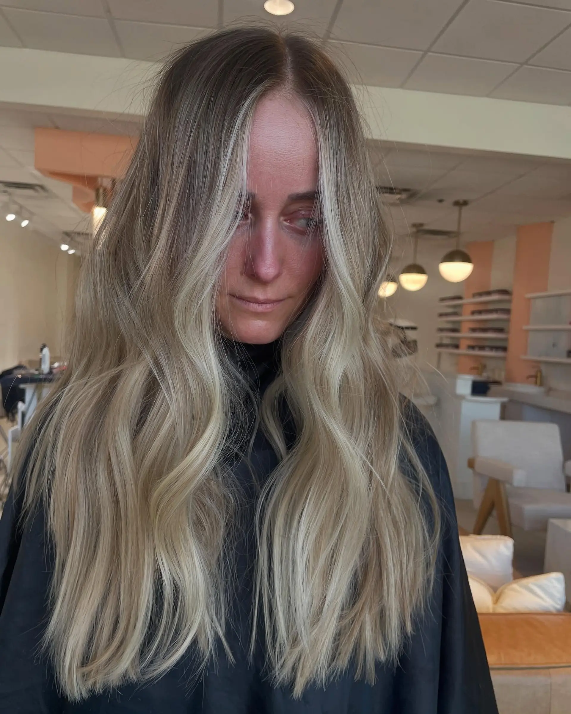 Long hair featuring dimensional blonde balayage with bright face-framing strands, styled in soft loose waves. 1