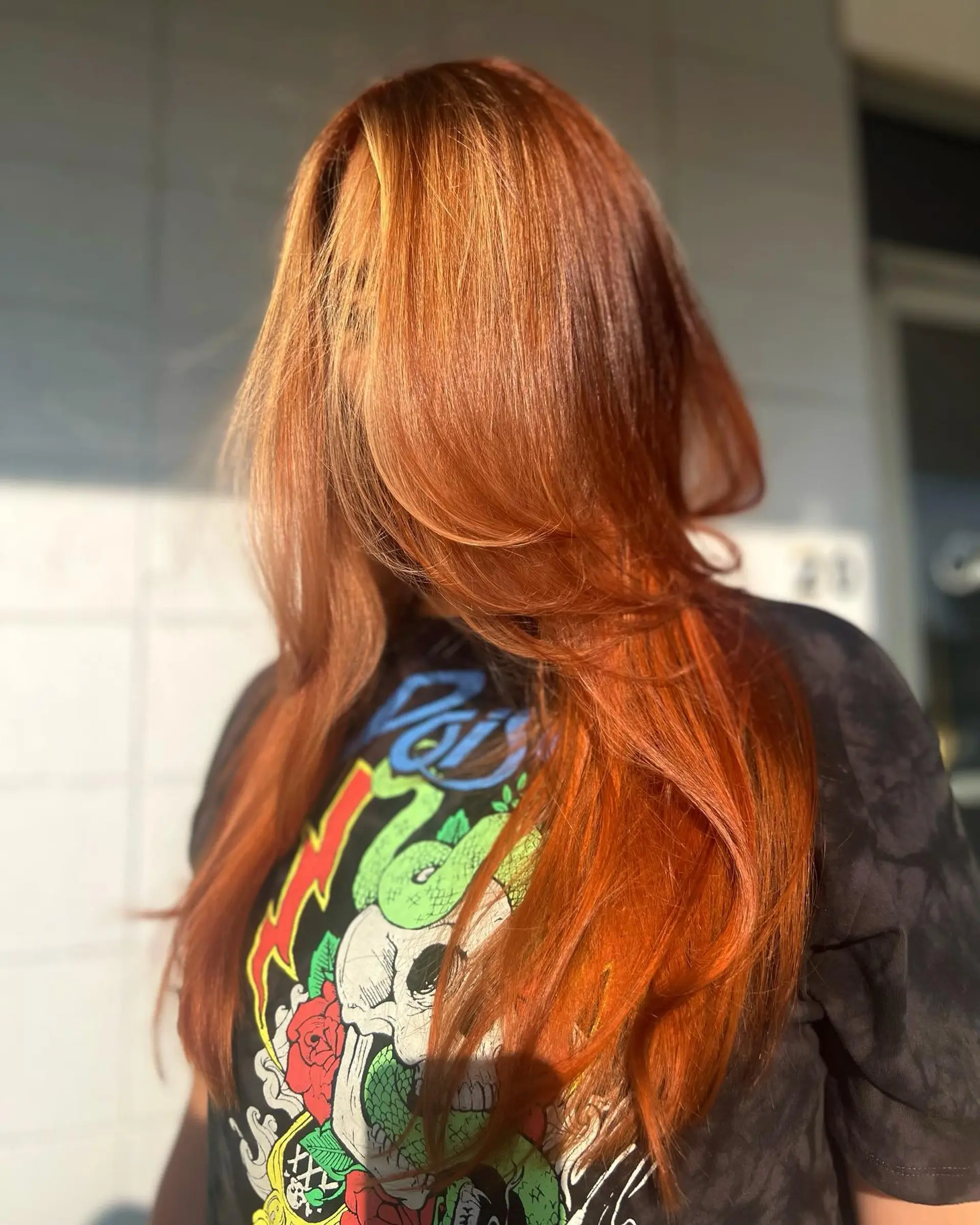 A radiant, vibrant copper color on long hair cut with face-framing layers and styled with a smooth, voluminous blowout. 1