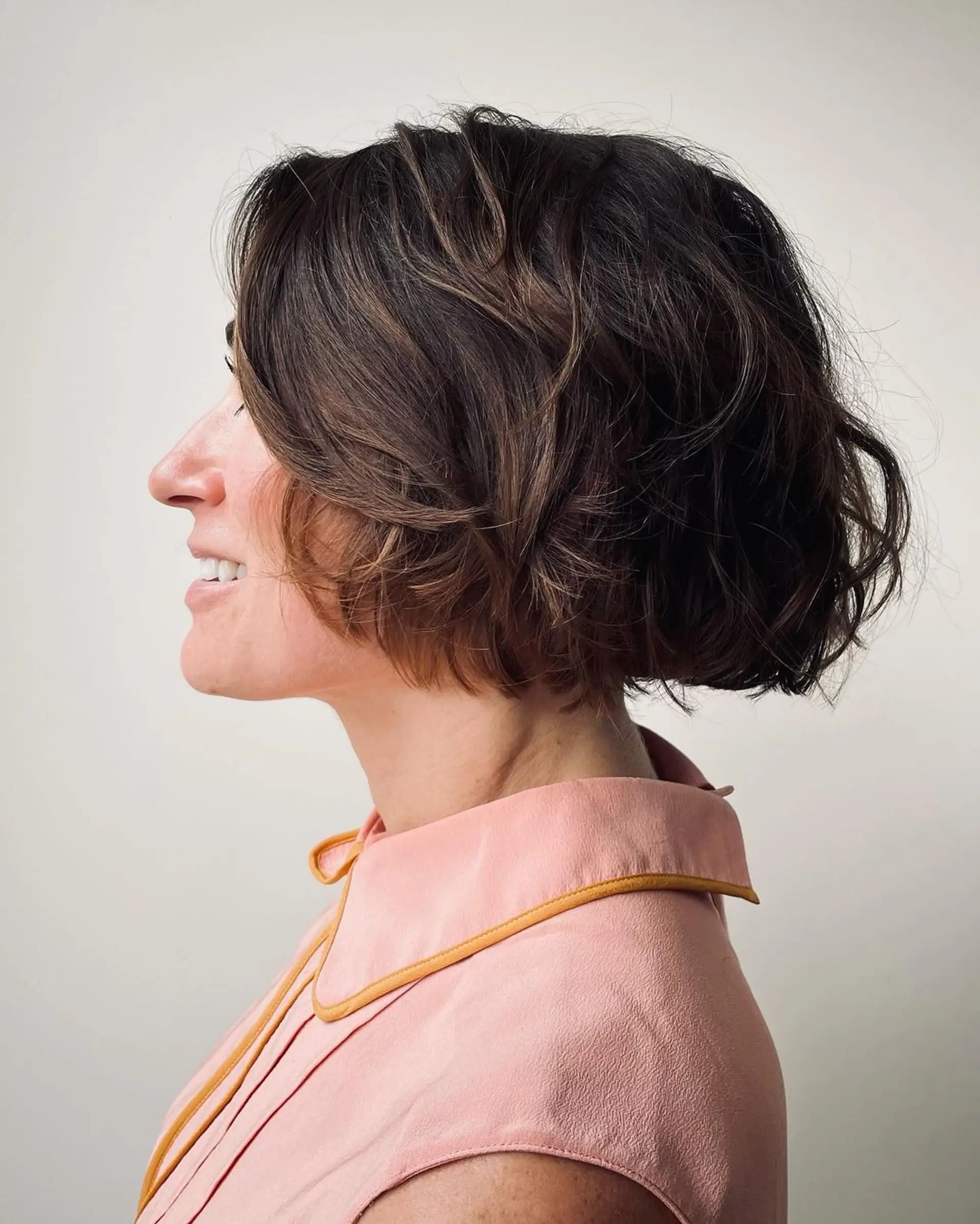 A short, wavy bob with a tousled, textured finish and subtle highlights for added depth. 1