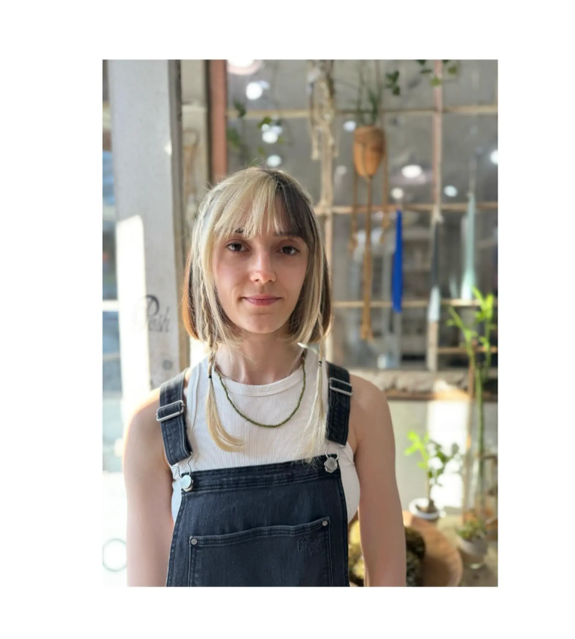 A trendy medium-length bob with a bold blonde money piece and blunt bangs. 1