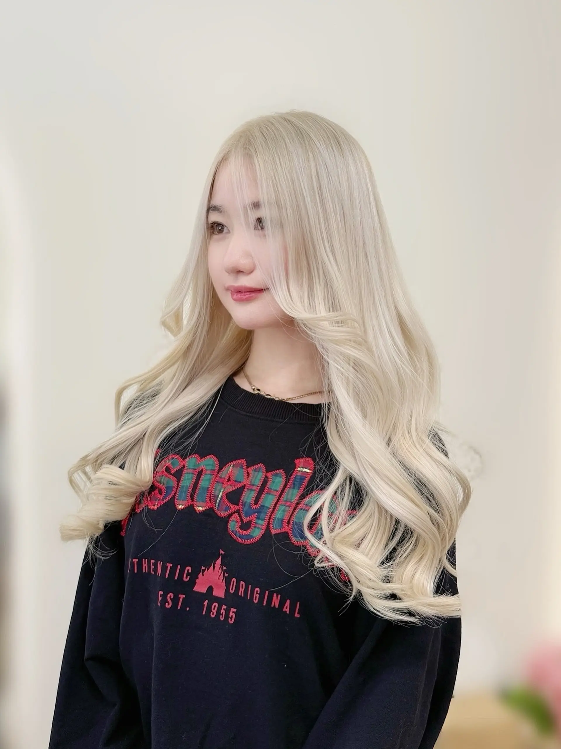 Long platinum blonde hair styled with voluminous, soft cascading waves and face-framing layers. 1
