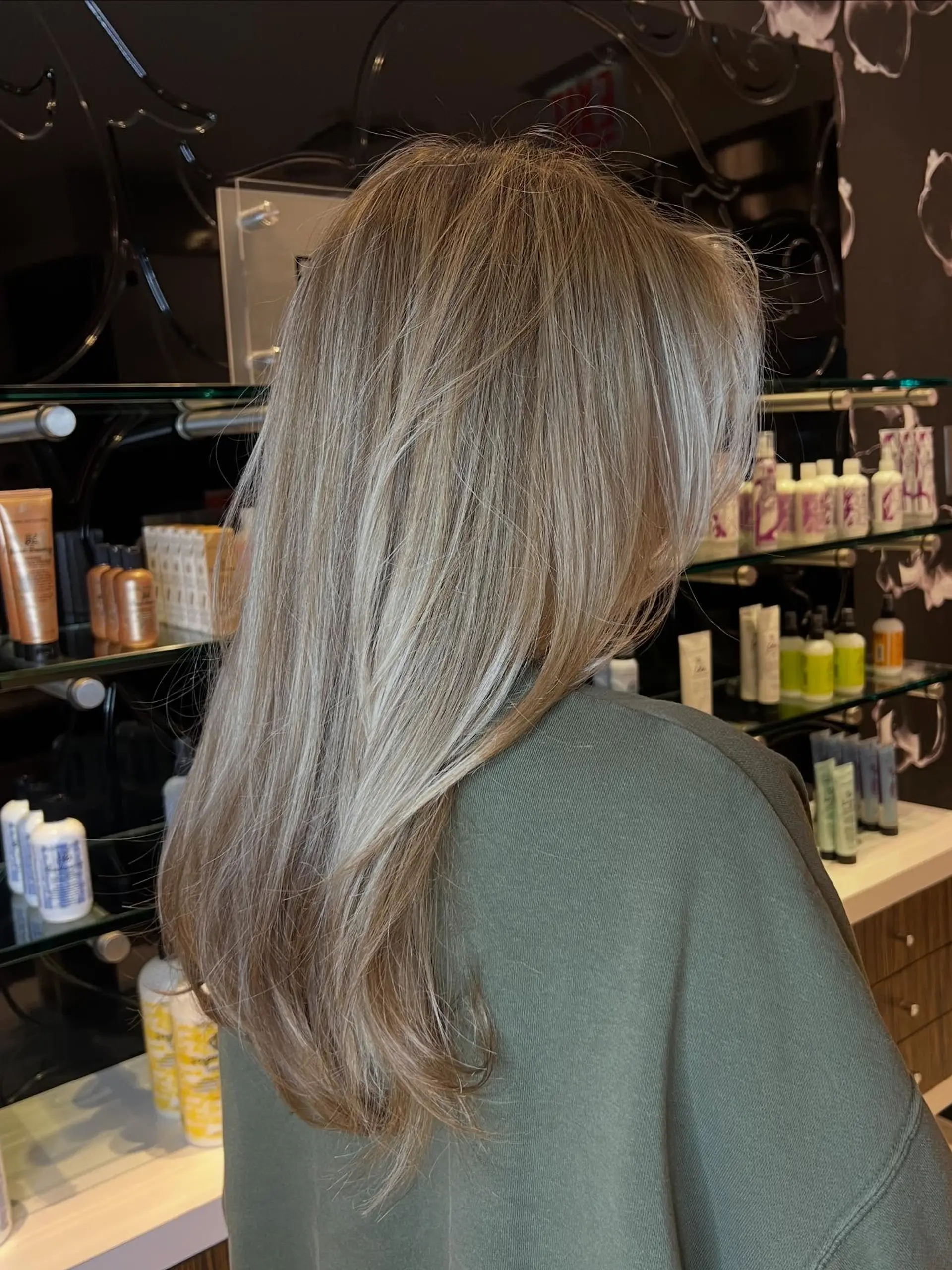 Long hair featuring bright dimensional blonde highlights, a bold face-framing money piece, and a sleek blowout with softly curved ends. 1