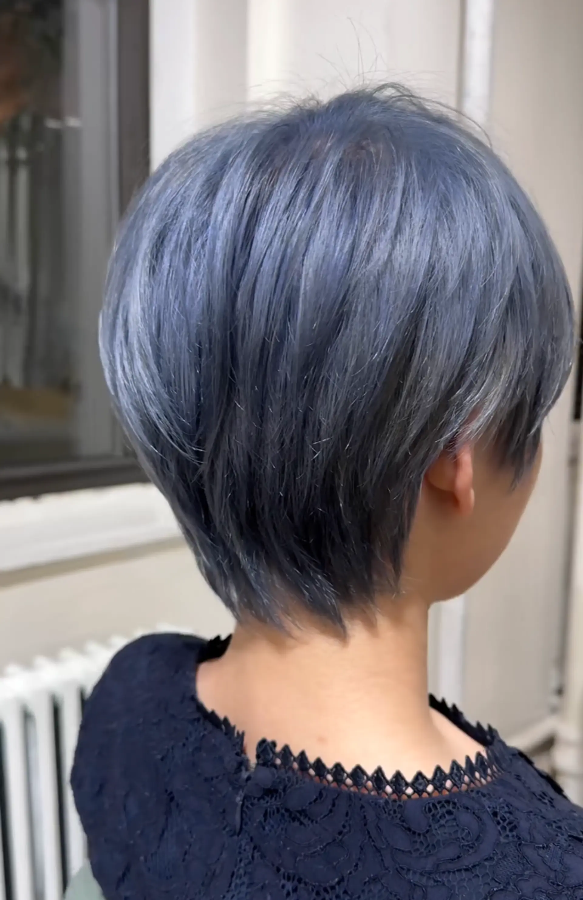 Sleek, short pixie cut with blue color, featuring layers and a textured, side-swept look. 2