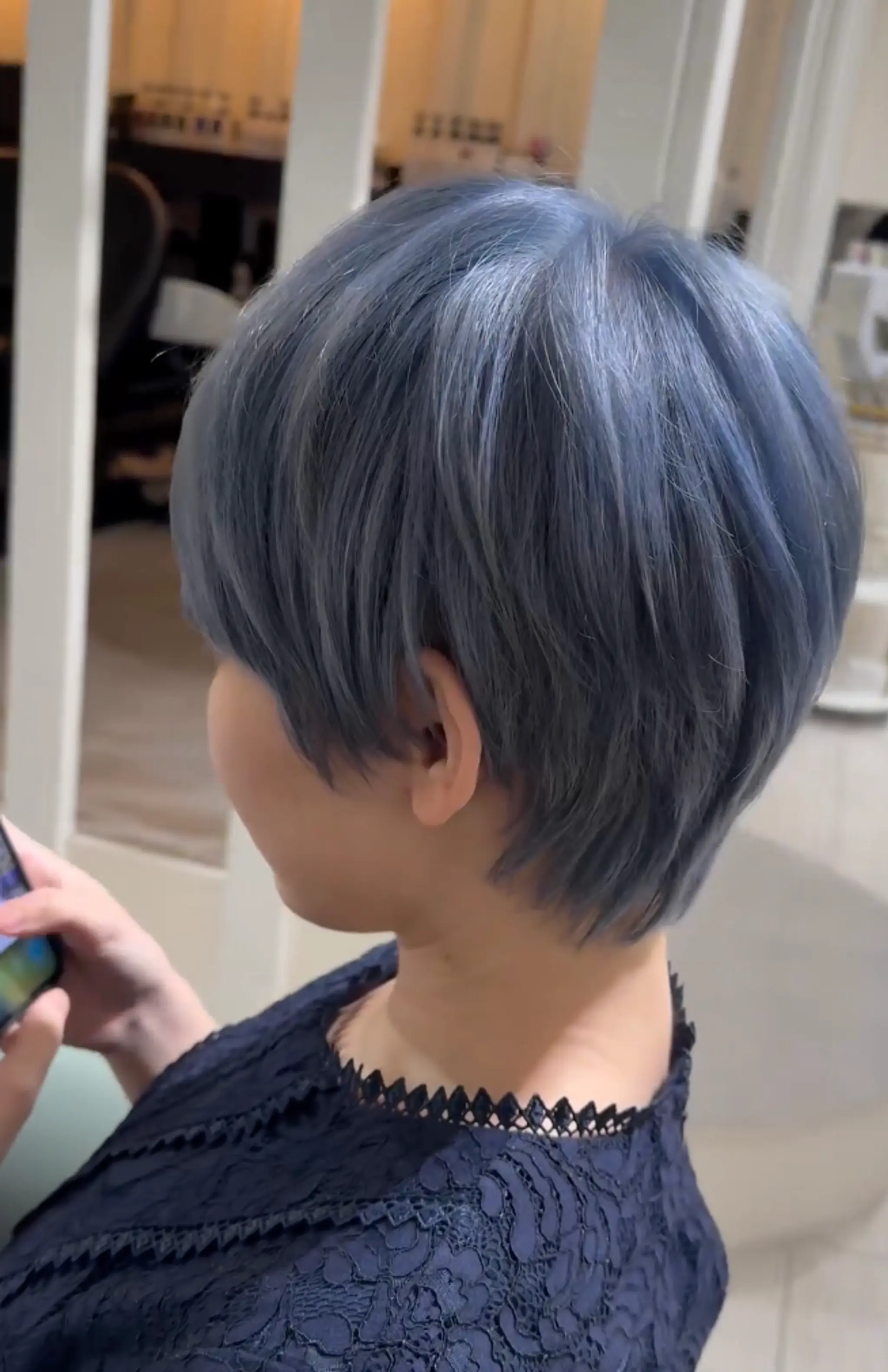 Sleek, short pixie cut with blue color, featuring layers and a textured, side-swept look. 1