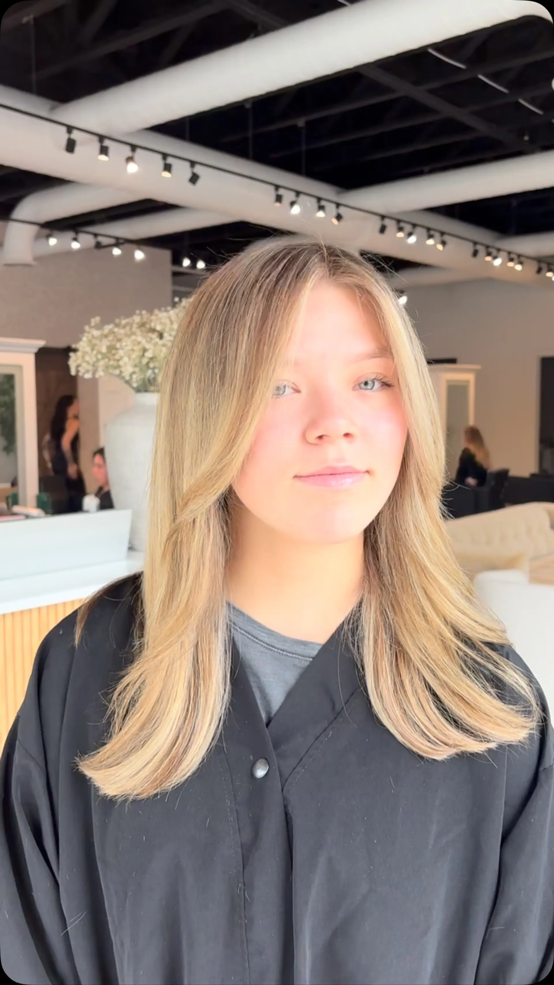 Long honey-blonde hair styled in a smooth blowout with softly curved ends and long face-framing curtain layers. 1