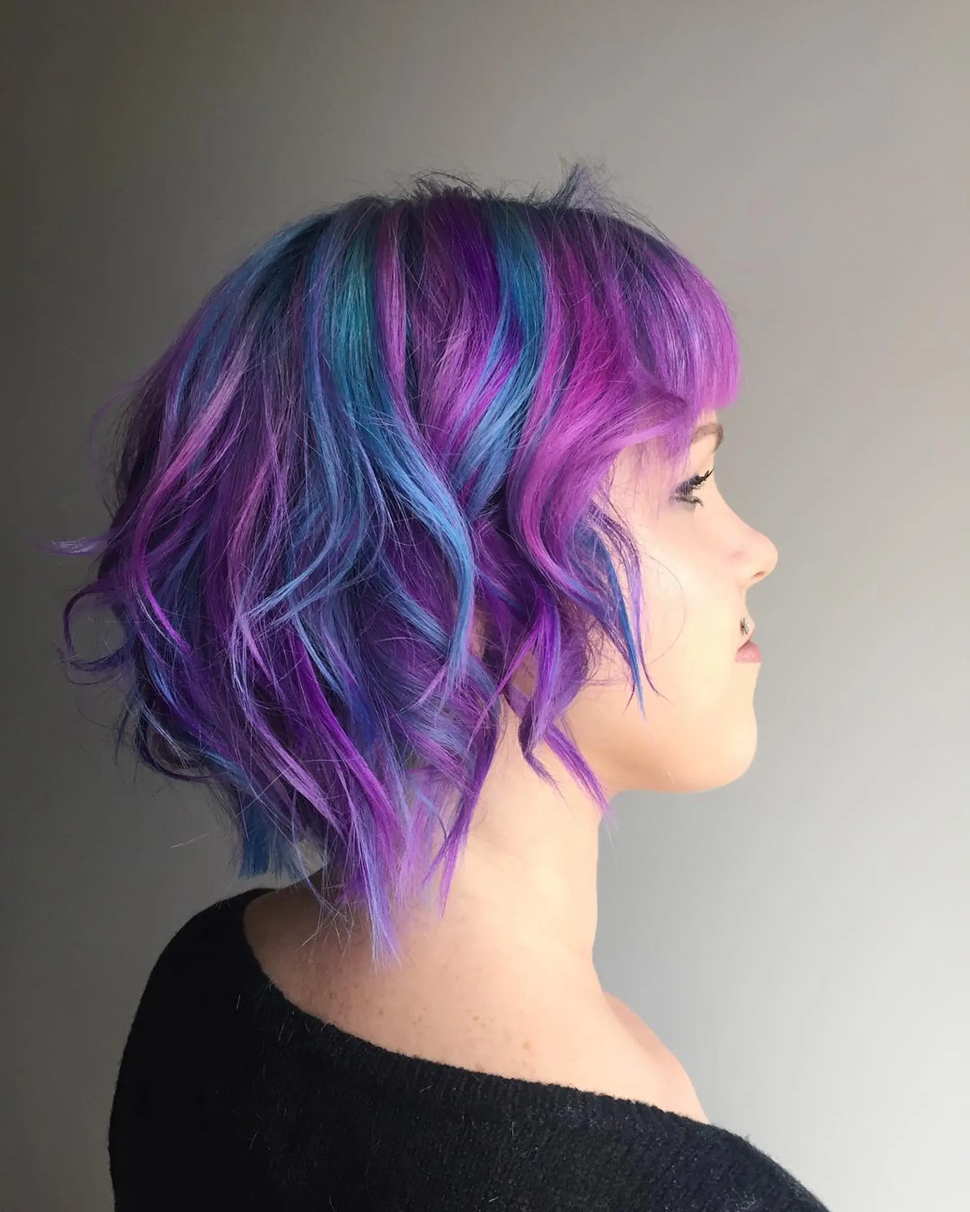 A short, wavy pixie with a layered cut and fantasy color. 1