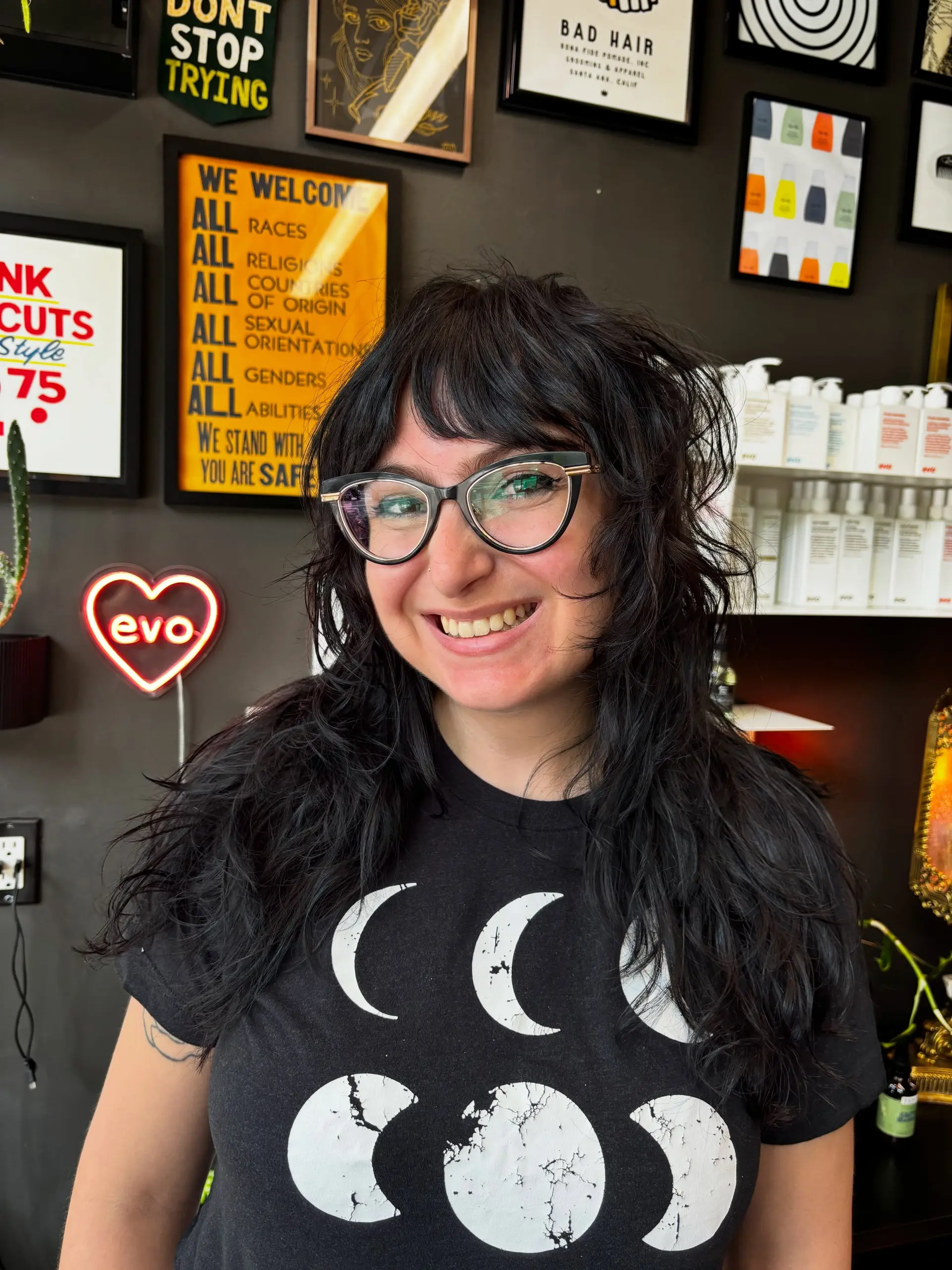 A textured black shag haircut featuring wispy, face-framing bangs and naturally diffused wavy layers. 1