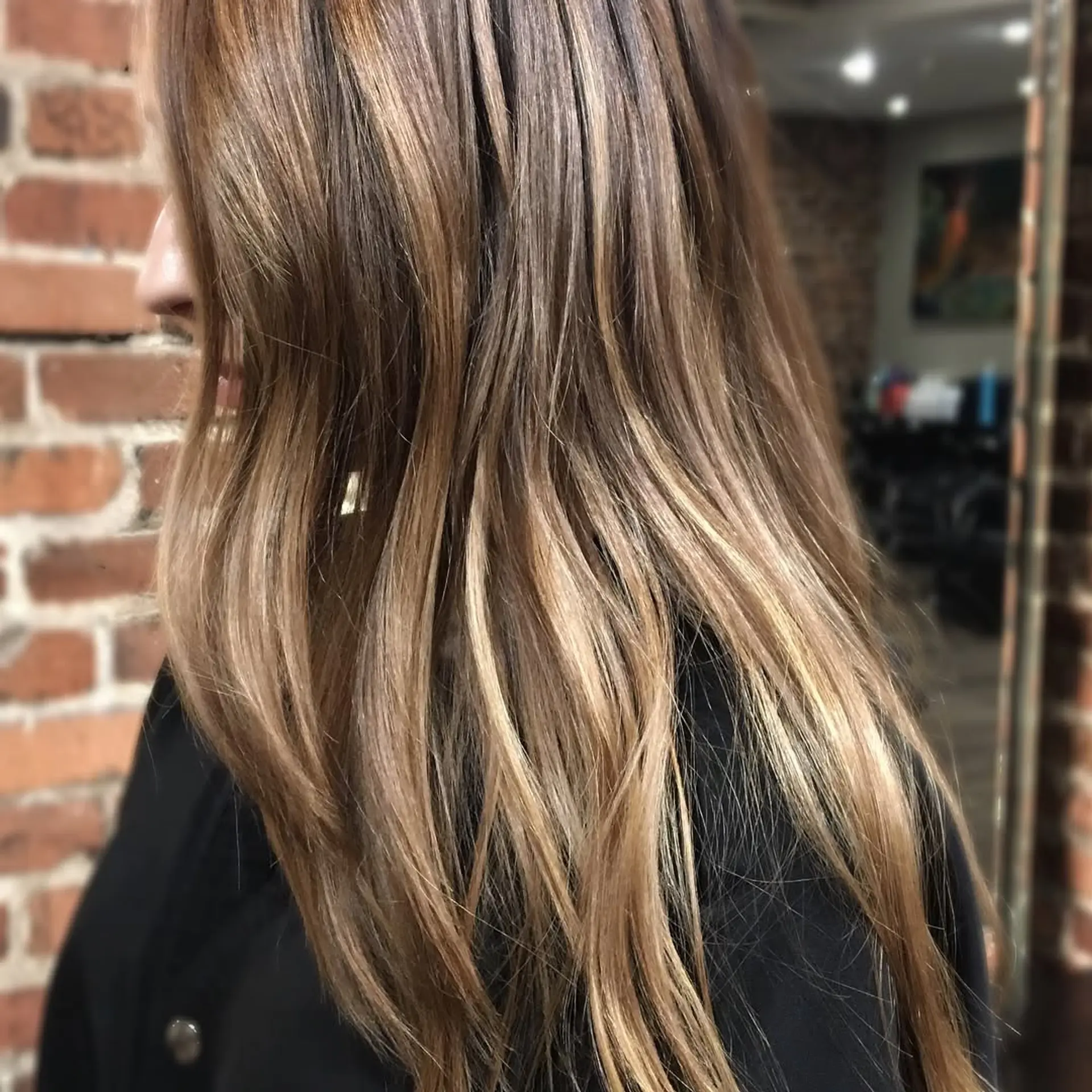 Long dimensional brunette hair with soft caramel and warm blonde balayage highlights. 1
