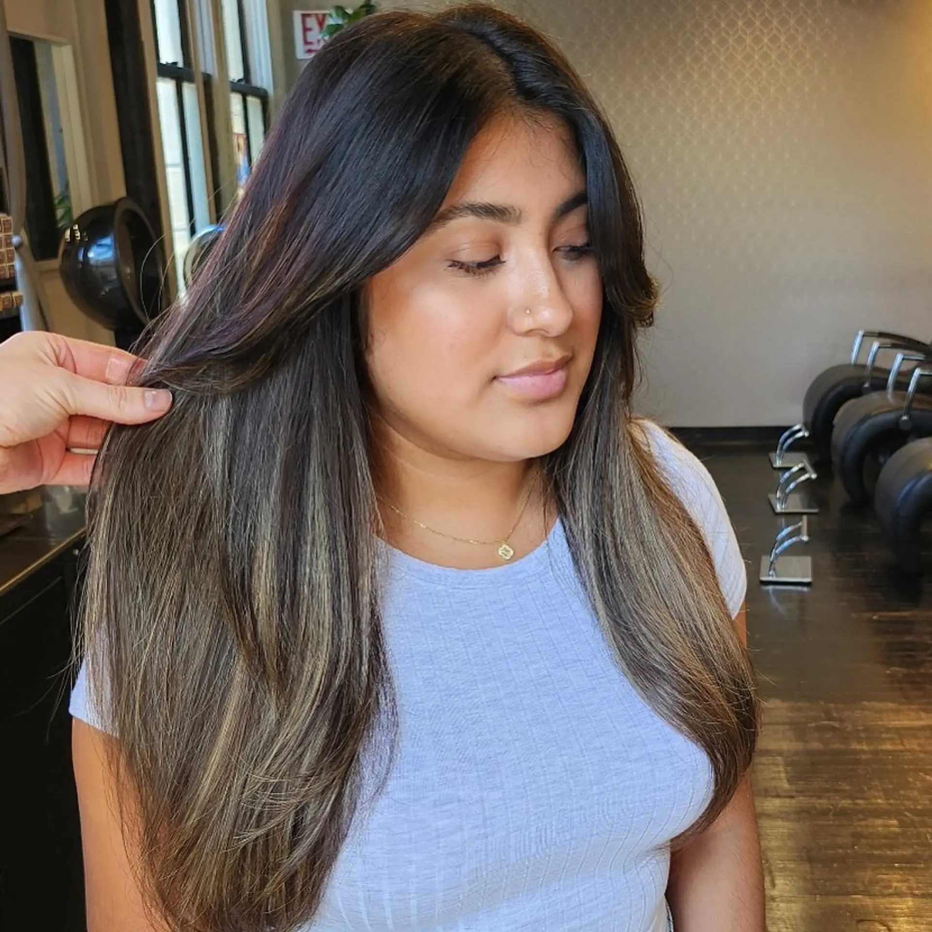 Long smooth brunette hair featuring soft dimensional balayage highlights and layered face-framing fringe. 1