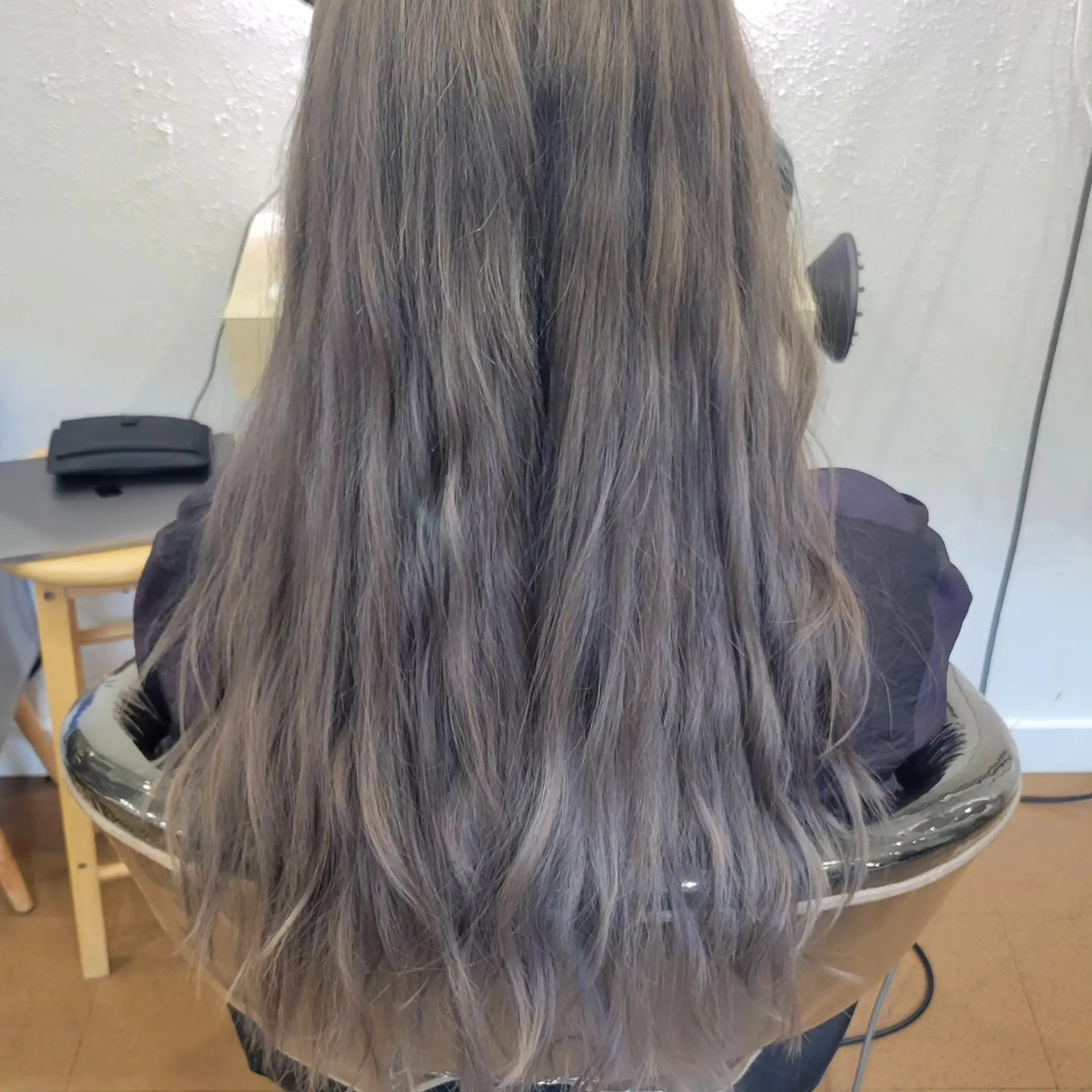 Long hair featuring soft, relaxed waves in a cool smoky ash gray tone. 1