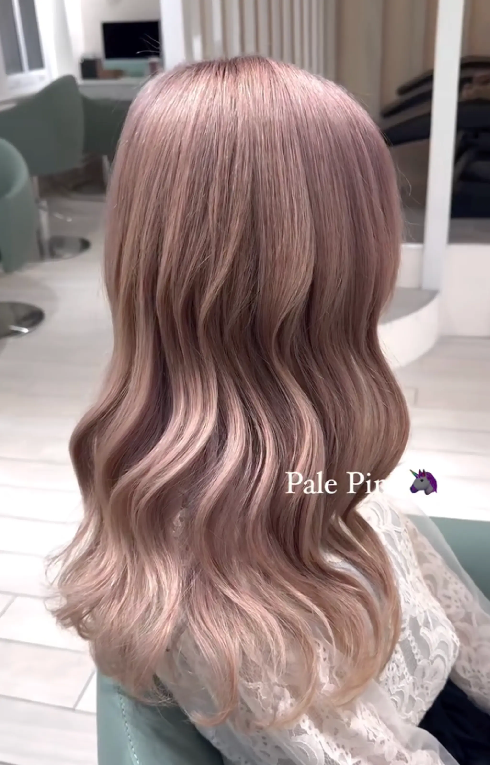 Soft, wavy locks cascading mid-length with pastel pale pink transitioning into blonde, reflecting a healthy shine.