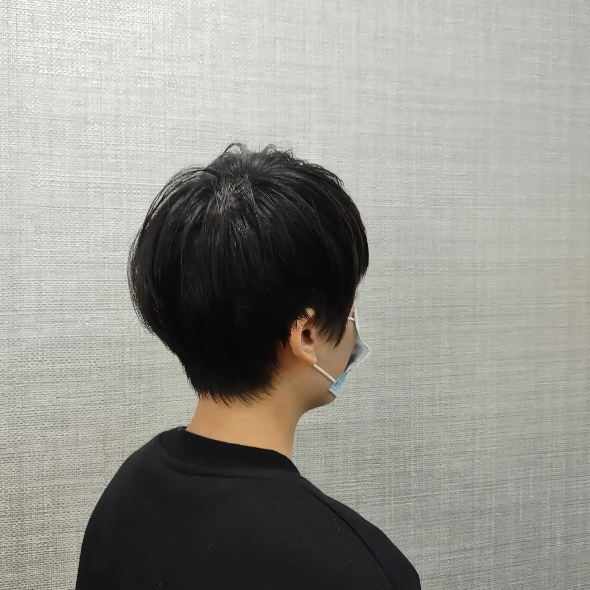 A short, softly textured pixie cut with gentle layering and a tapered neckline. 1