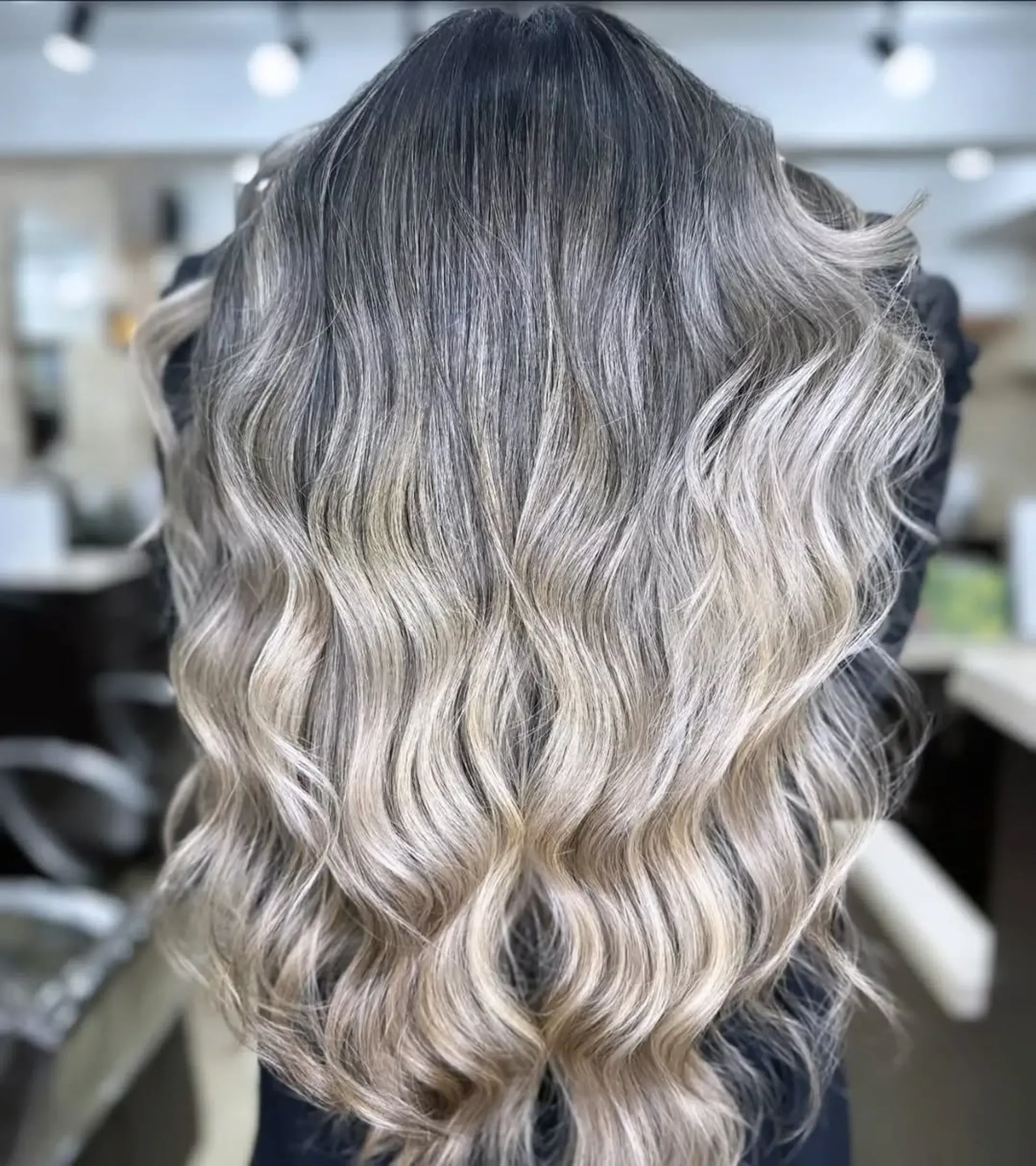 A beautiful ombre with dark roots transitioning into a blonde with a wavy style. 1