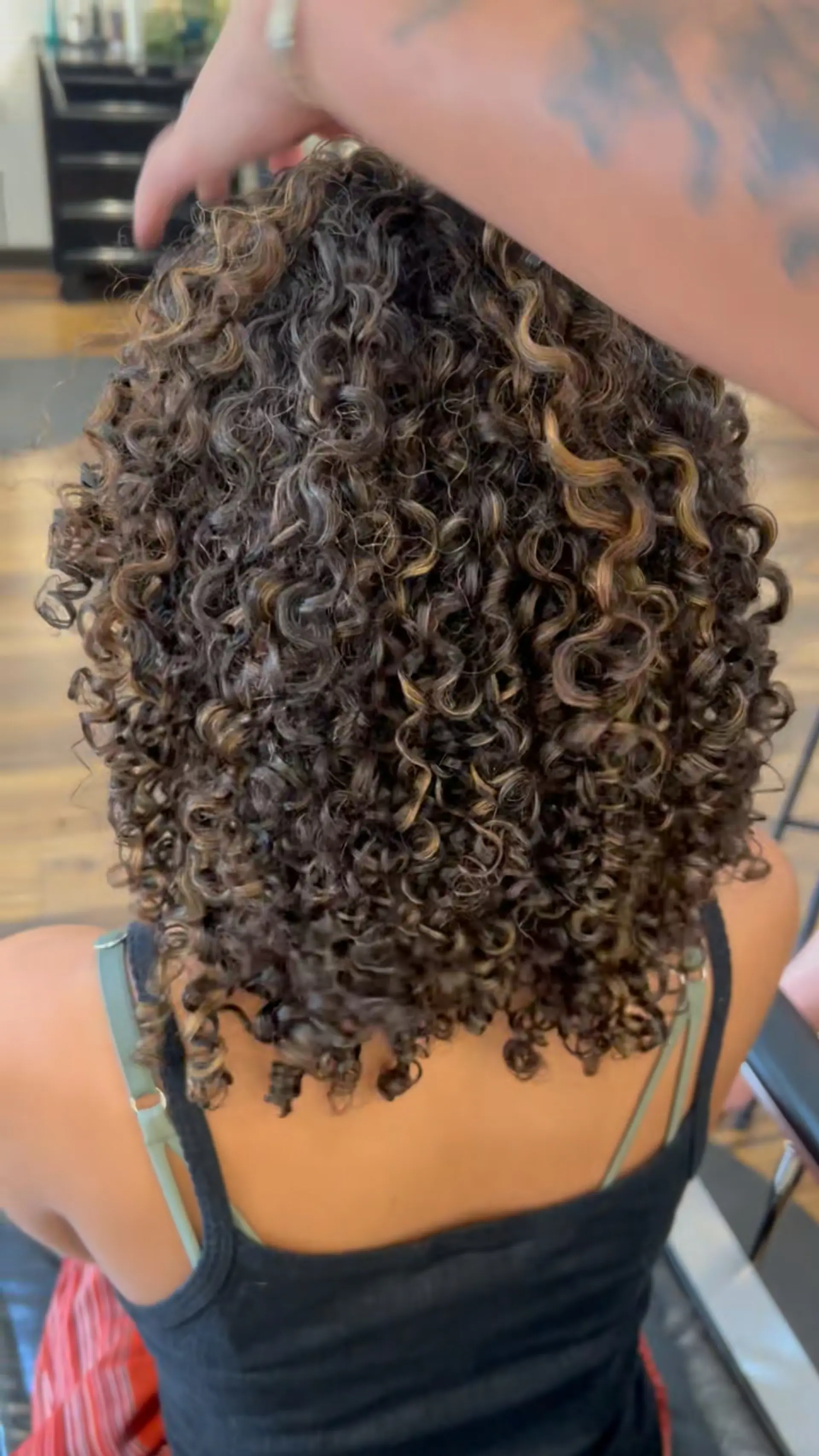 Medium-length defined ringlets enhanced with warm, sun-kissed caramel pintura highlights. 1