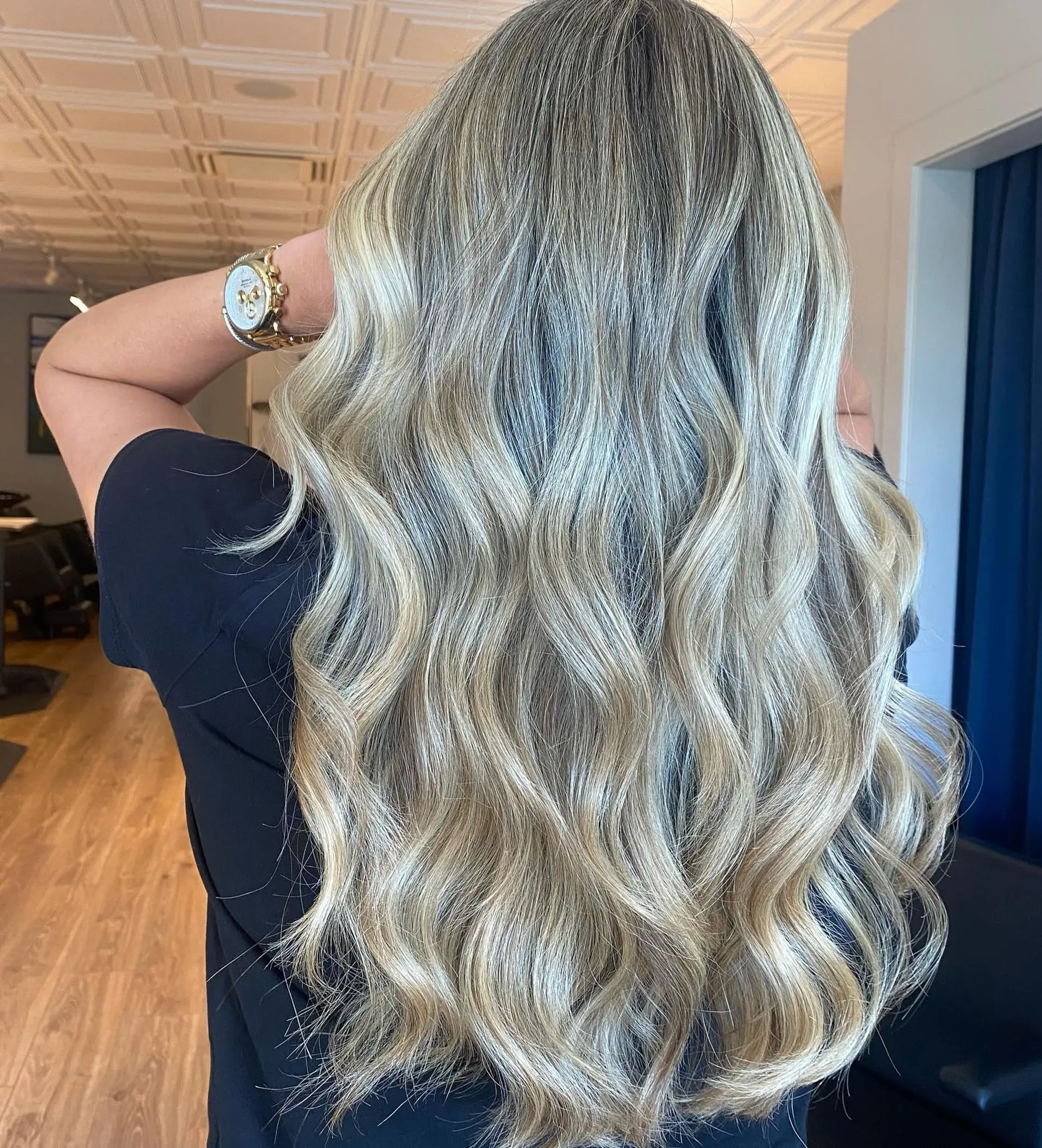 Long cascading hair featuring seamless ash blonde balayage styled into soft, dimensional waves. 1