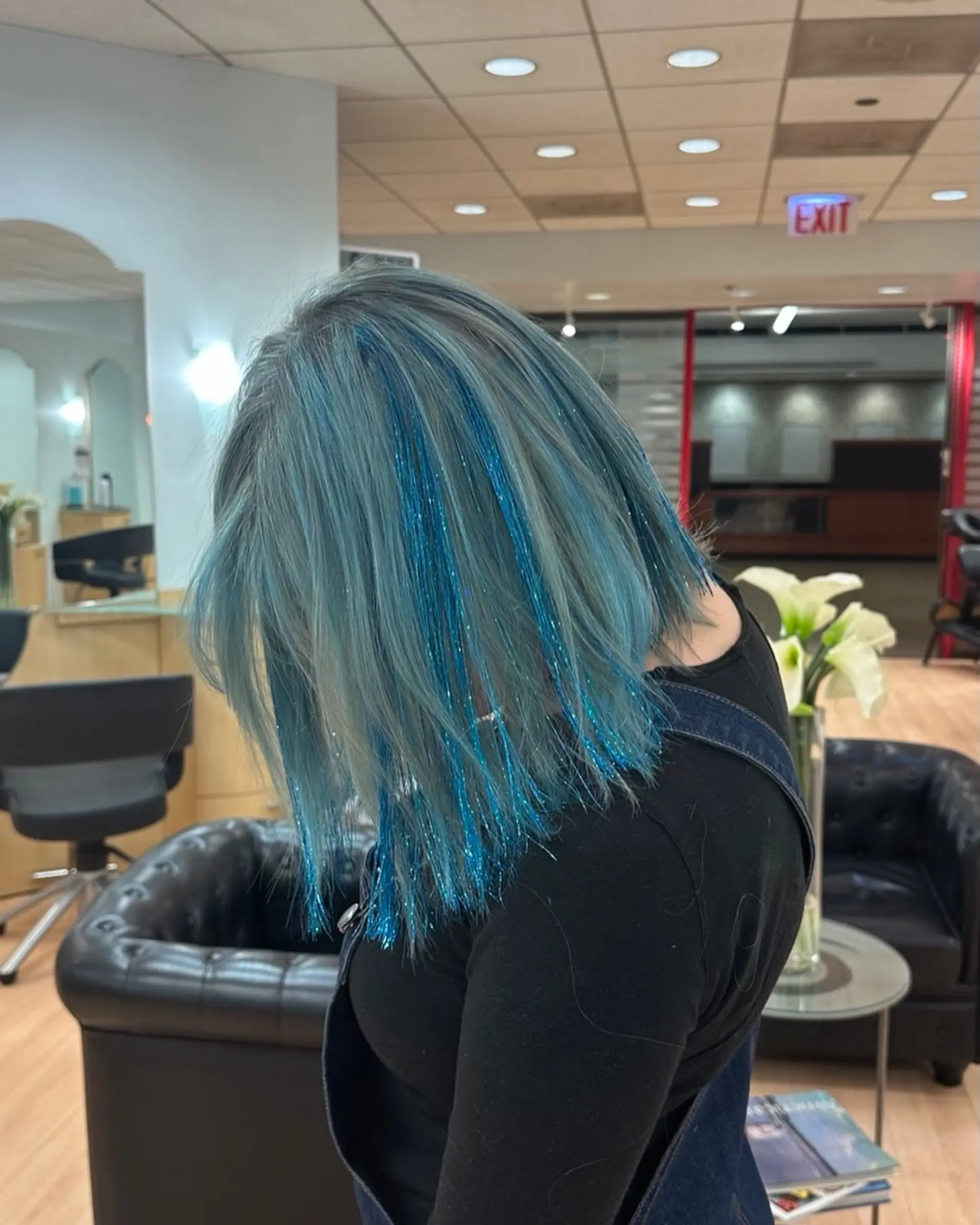 A textured shoulder-length lob in an icy pastel blue shade accented with vibrant sparkling blue hair tinsel strands. 1