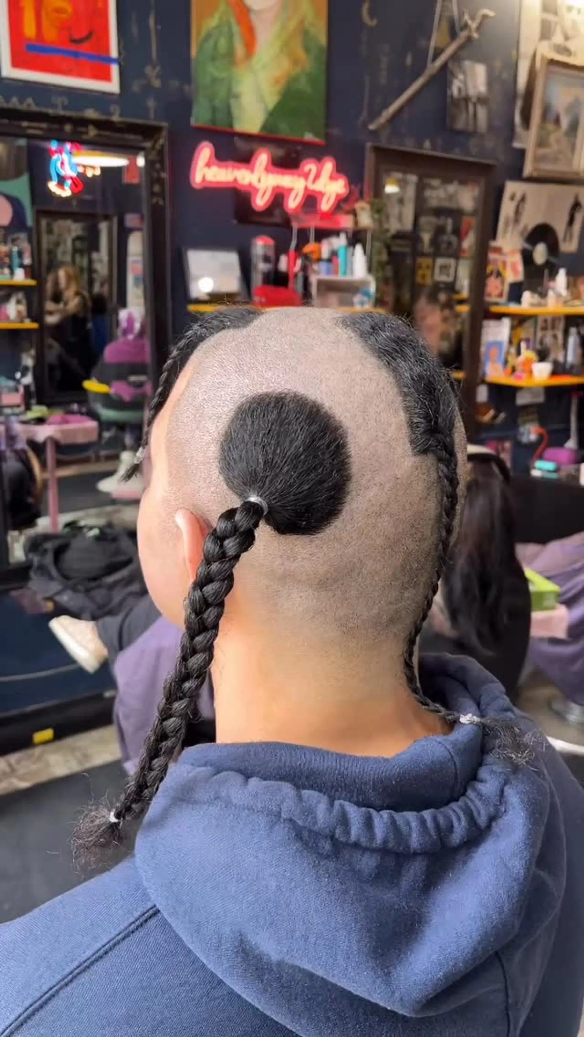 An avant-garde shaved cut featuring isolated hair sections gathered into long, sleek braids. 1
