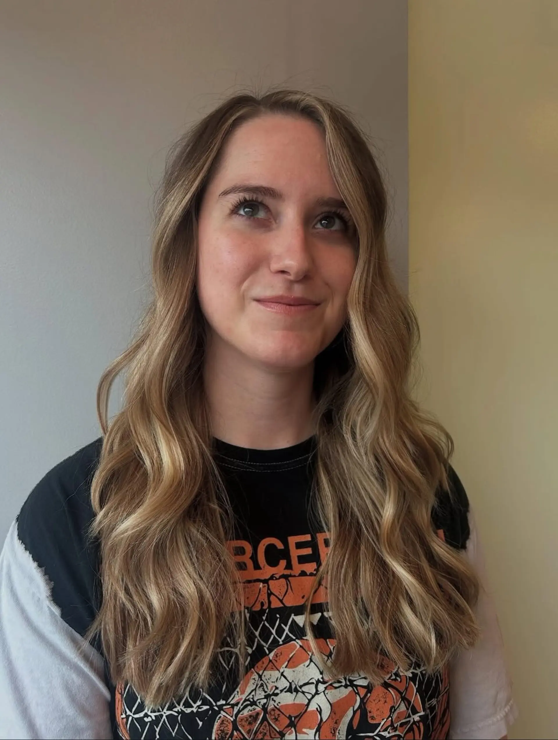 Long layered hair styled in soft, loose waves featuring warm golden blonde balayage with face-framing highlights. 1