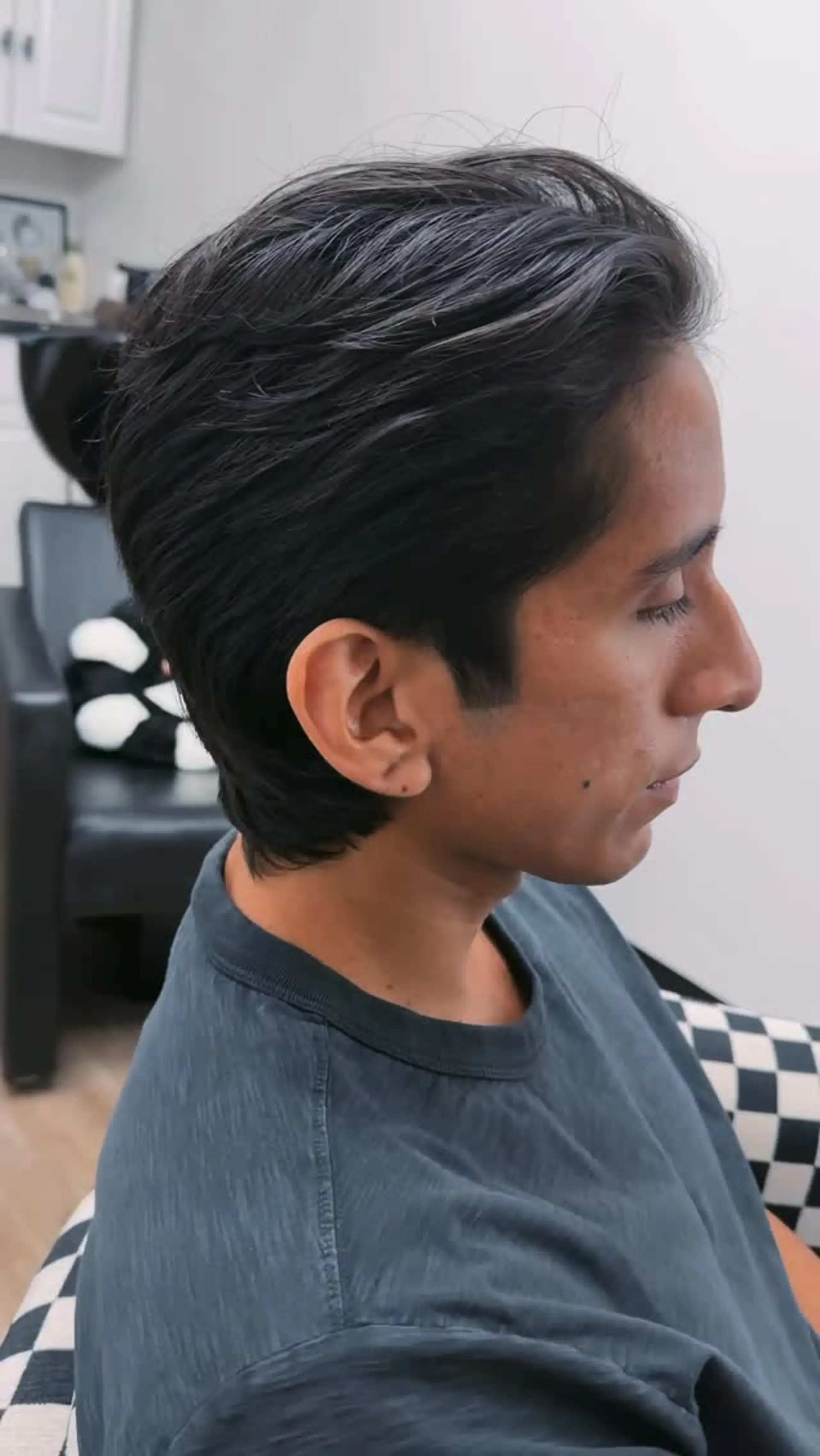 A mid-length haircut styled in a textured, swept-back flow with natural volume and cleanly tapered sides. 1