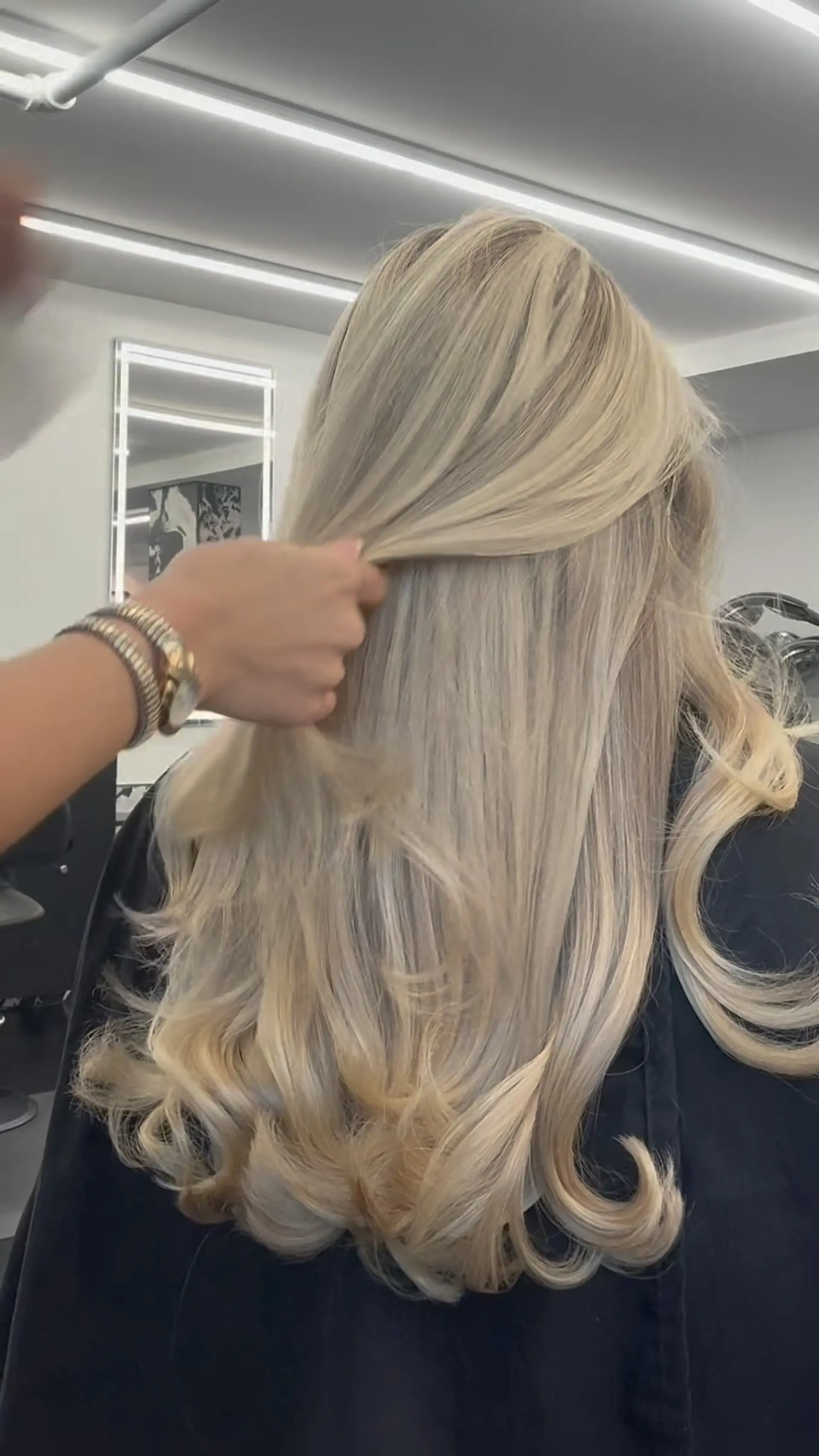 Long, luminous platinum blonde hair styled with soft flowing layers and voluminous curled ends. 1
