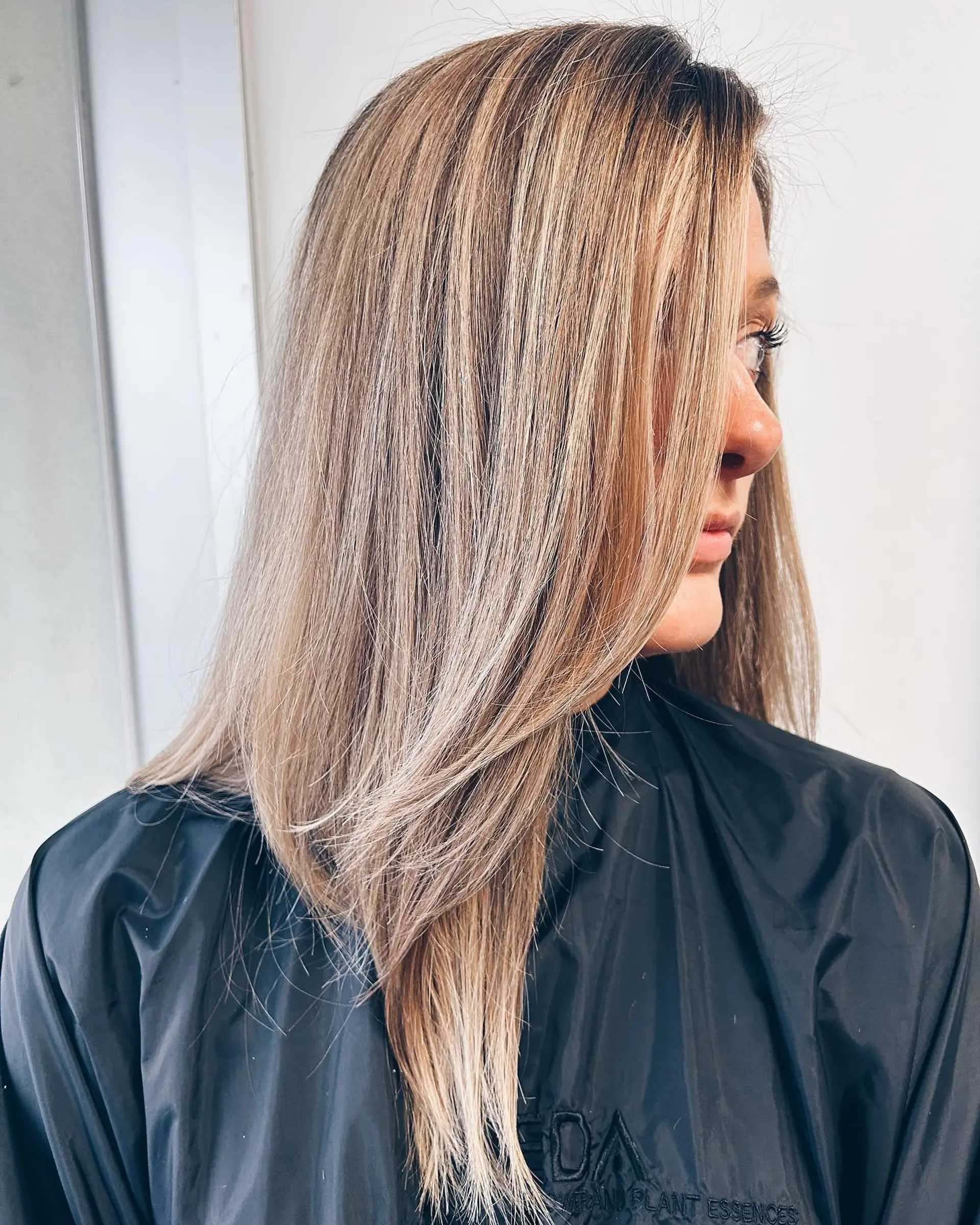 Long straight hair featuring fine dimensional blonde balayage highlights with face-framing layers. 1