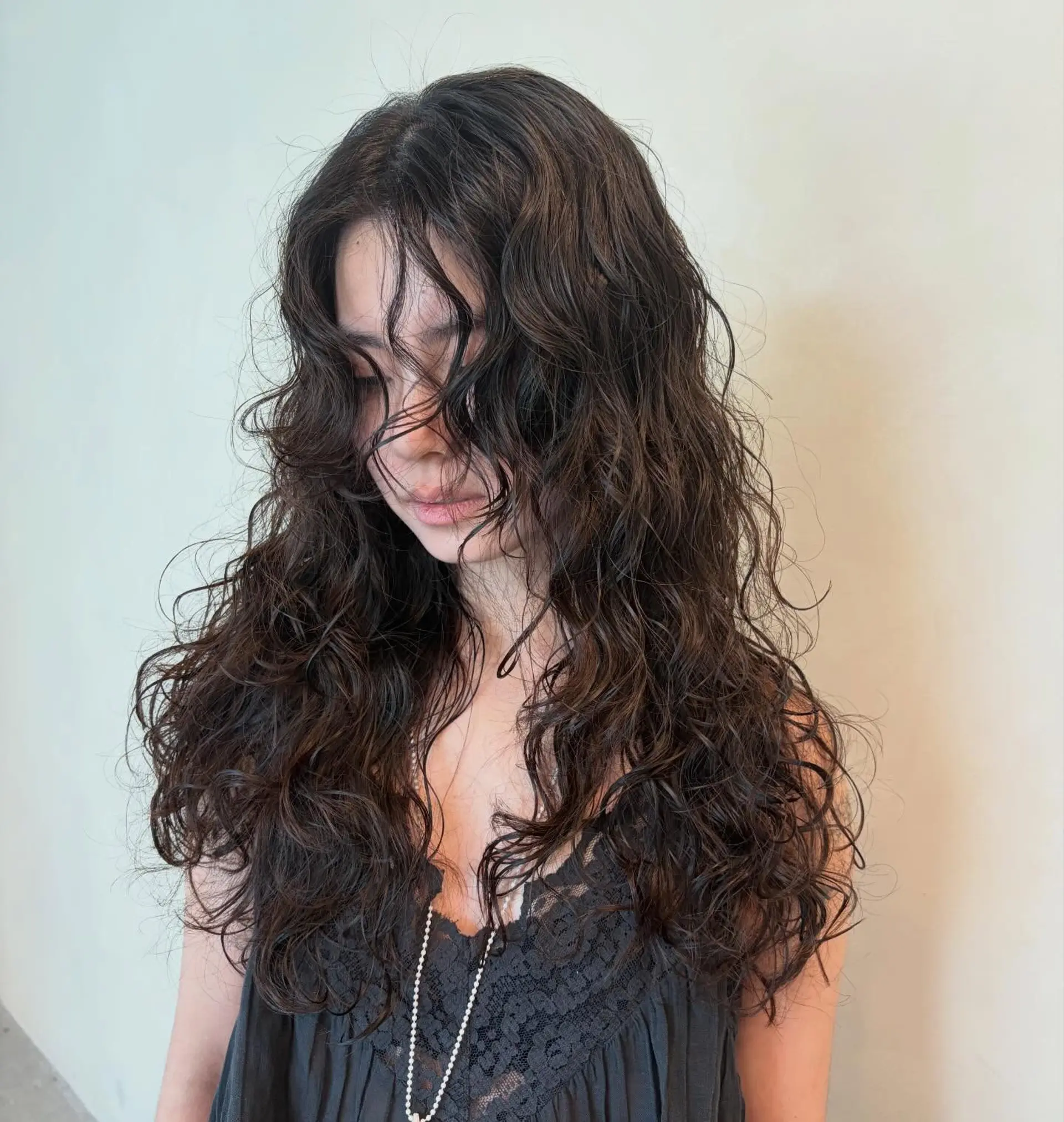 Long dark brown hair styled with soft, voluminous, and tousled vintage waves. 1
