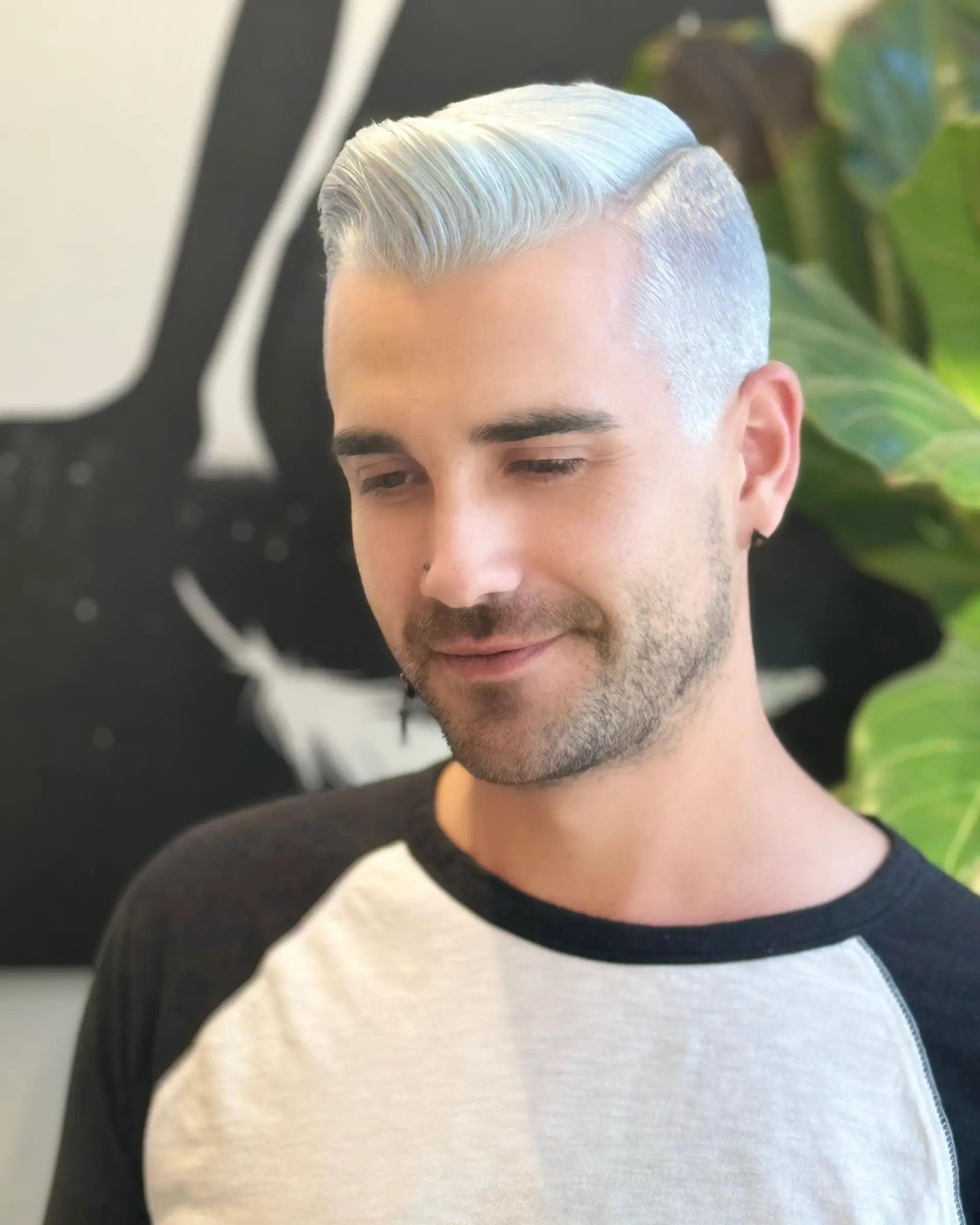 A sleek side-parted short hairstyle dyed in an ultra-cool icy platinum shade with soft blue undertones. 1