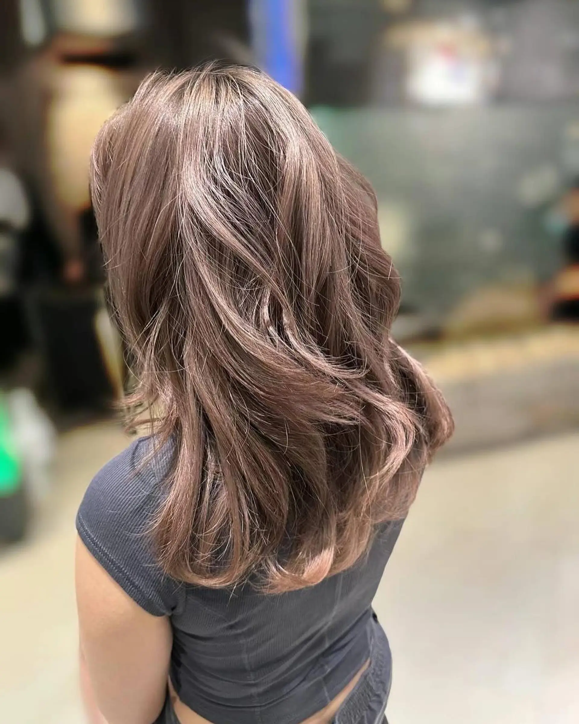 A medium-length, wavy hairstyle featuring a layered cut and soft waves. 1