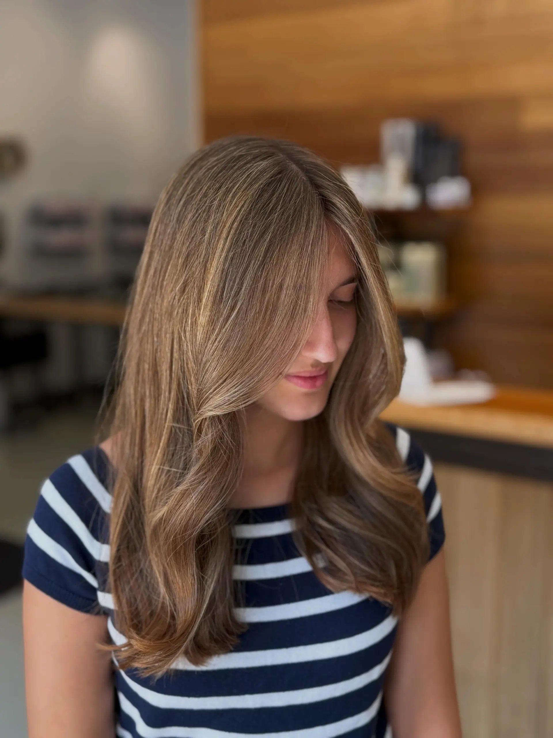 Long dimensional golden blonde hair styled in a polished, voluminous blowout with soft face-framing curtain layers. 1