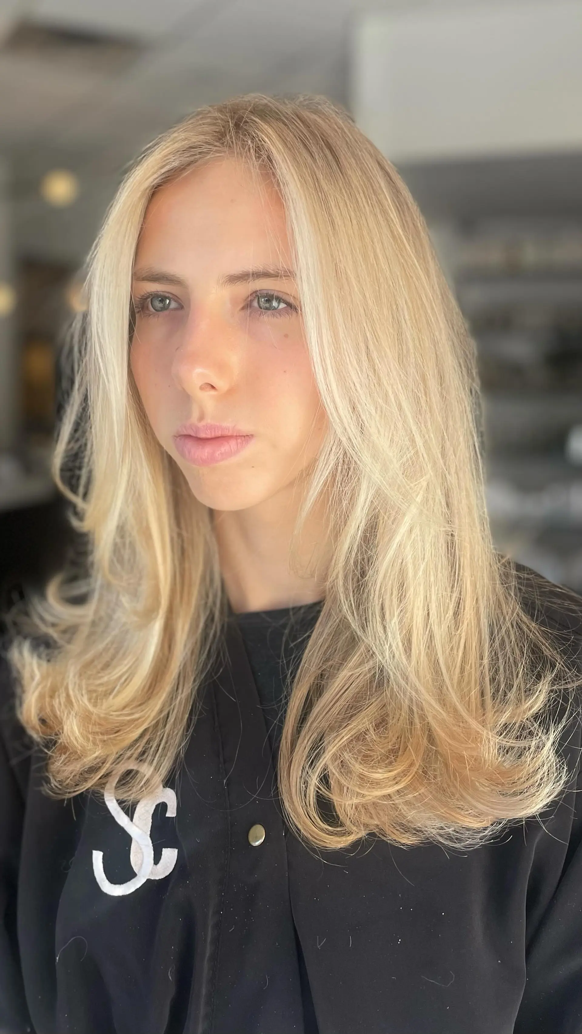 Long luminous blonde hair cut with face-framing layers and styled in a bouncy blowout. 1