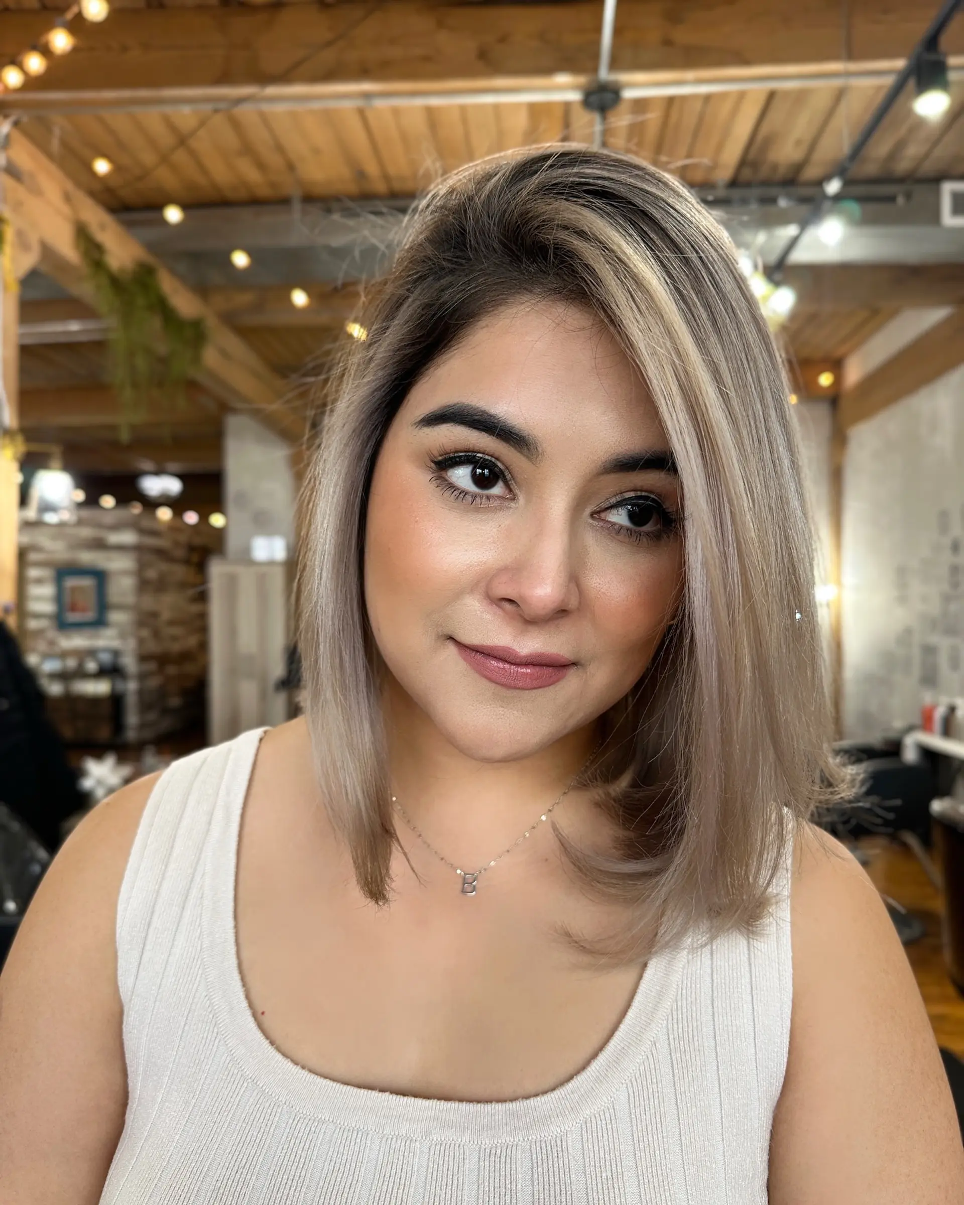 A stylish, medium-length blunt bob with an icy blonde color. 1