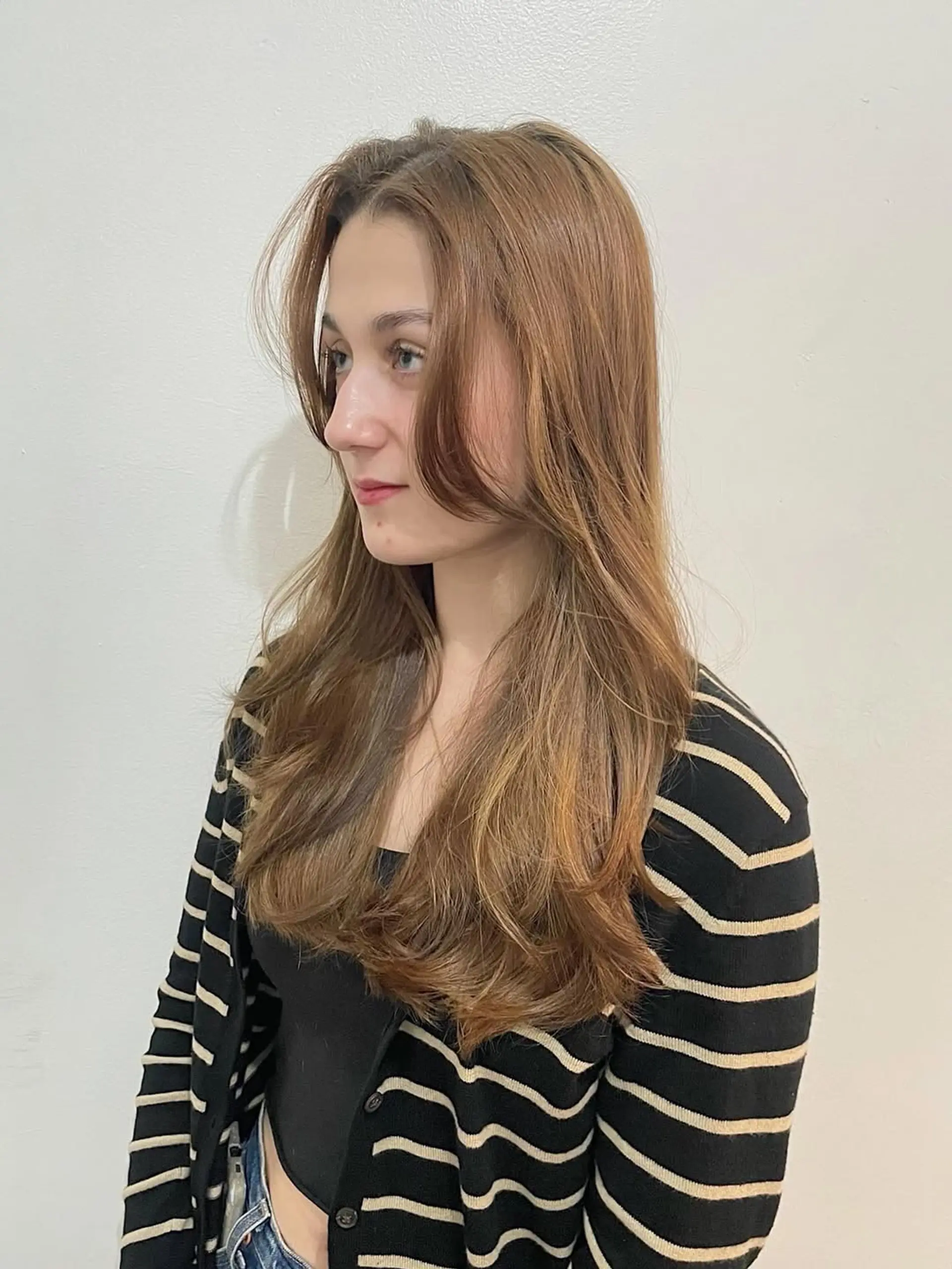A stunning long haircut featuring a butterfly cut with voluminous layers and elegant face-framing pieces that softly sweep away from the face, creating a flattering and airy silhouette with plenty of movement. 1