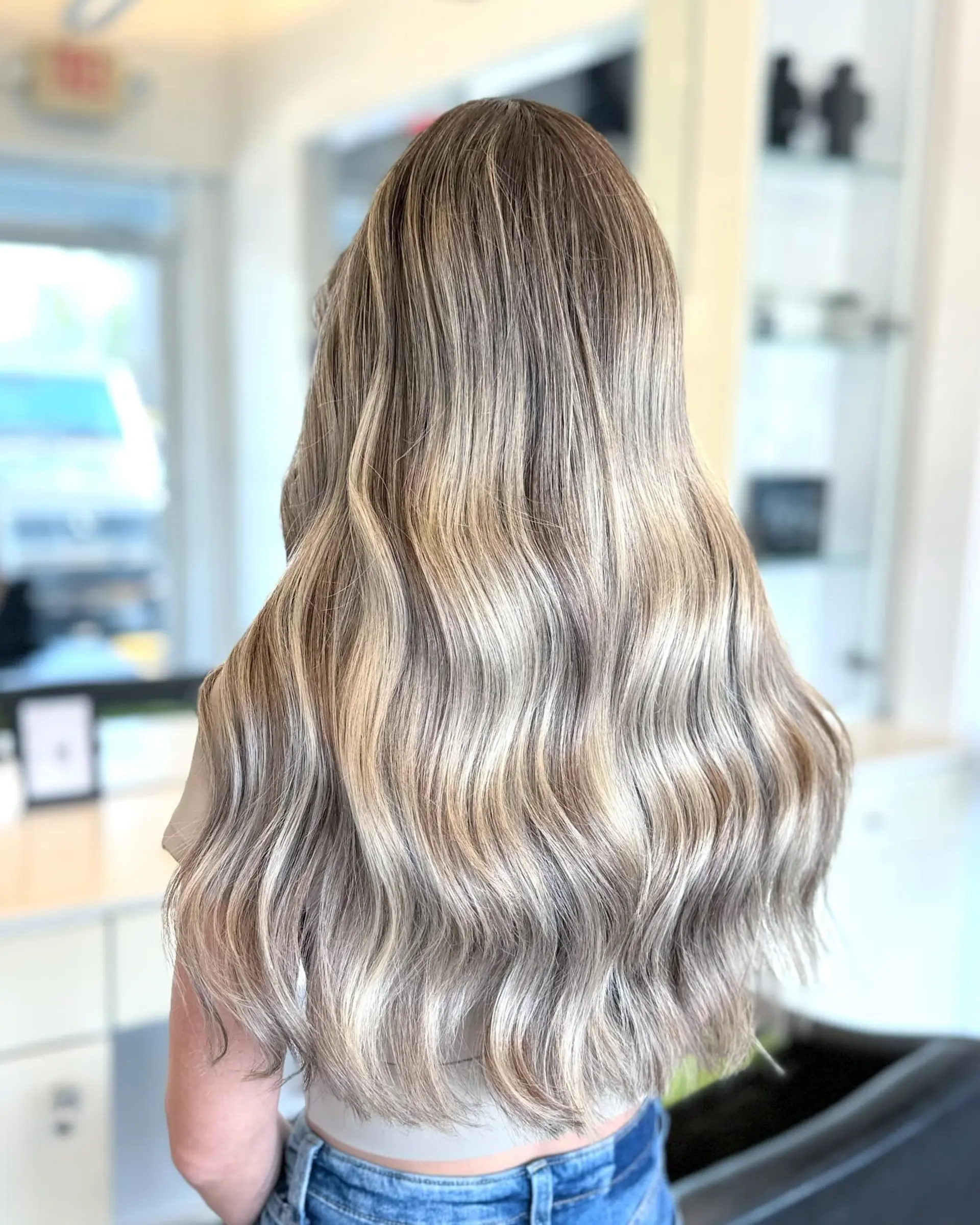 Long, flowing beach waves with a dimensional blonde balayage. 3