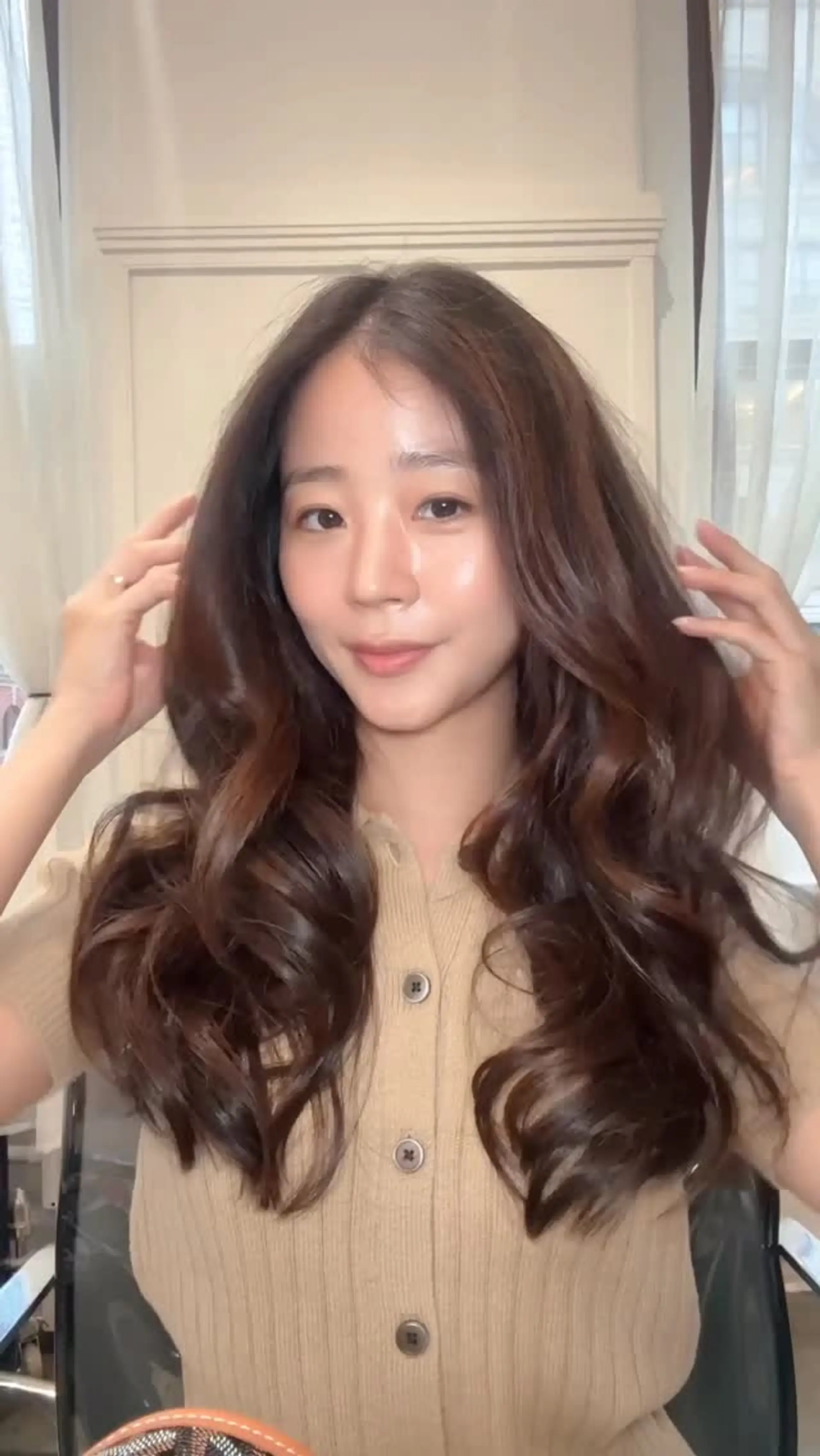 Long chocolate brown hair featuring soft, dimensional balayage highlights styled in bouncy, voluminous waves. 1